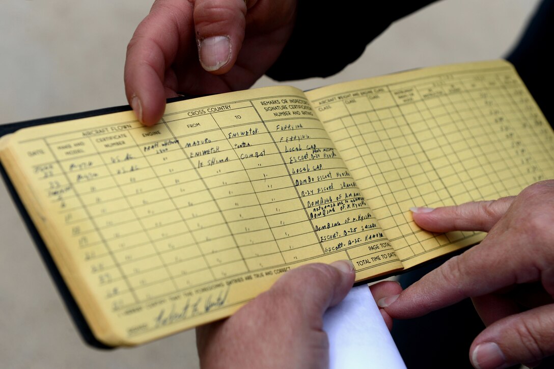 The log book of retired Air National Guard Chief Warrant Officer 2 Robert Hertel is looked at during the Heritage Flight Training and Certification Course at Davis-Monthan Air Force Base, Ariz., Feb. 28, 2015. The book showed the 92-year-old veteran's, flights over Iwo Jima, Japan during World War II. (U.S. Air Force photo by Senior Airman Jensen Stidham/Released)