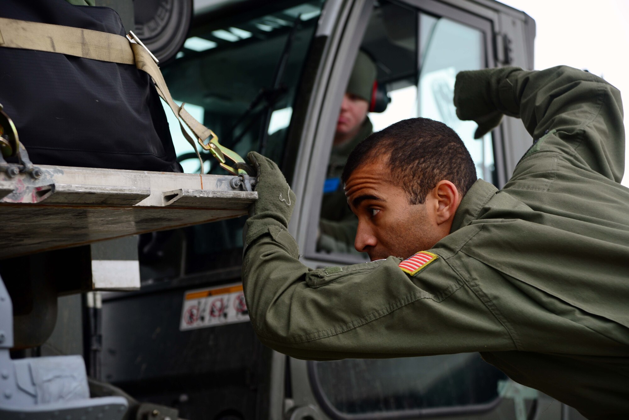 Senior Airman Cameron Davis, 146th Airlift Wing loadmaster, guides Airman 1st Class Aaron Holmstedt, 35th Logistics Readiness Squadron, while loading a pallet of cargo onto a C-130 Hercules during an Operational Readiness Exercise at Misawa Air Base, Japan, March 1, 2015. Airmen worked through the weekend to prepare members to deploy to the Republic of Korea in support of Exercise Beverly Sunrise 15-2. (U.S. Air Force photo by Staff Sgt. Derek VanHorn/Released)
