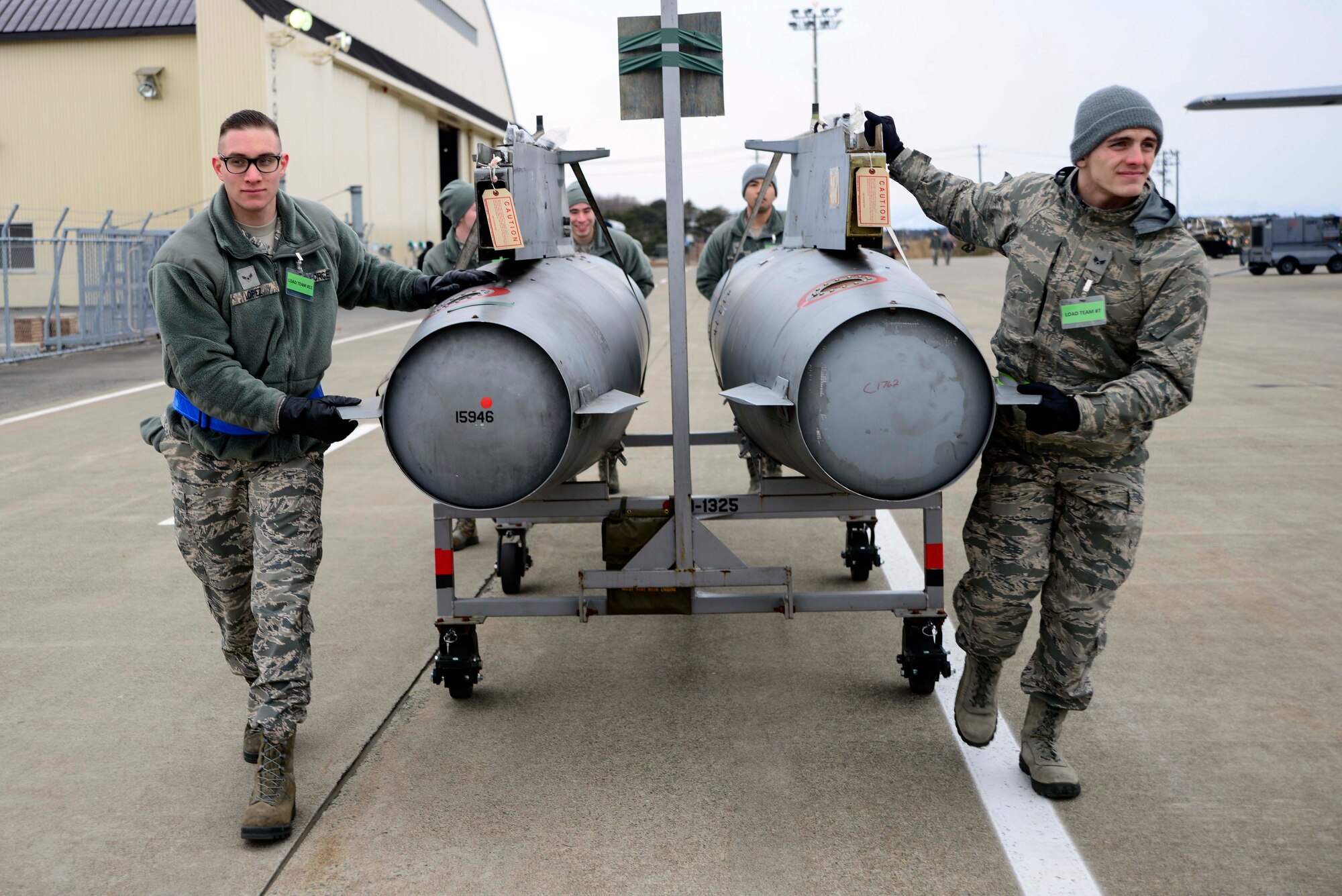 Cargo deployment line augmentees from the 35th Medical Group transfer fuel pods to a C-130 Hercules during an Operational Readiness Exercise at Misawa Air Base, Japan, March 1, 2015. When an exercise begins, Airmen are often transferred to different work stations to meet prominent mission requirements. Around 30 Airmen worked to prepare cargo pallets for deploying Airmen. (U.S. Air Force photo by Staff Sgt. Derek VanHorn/Released)