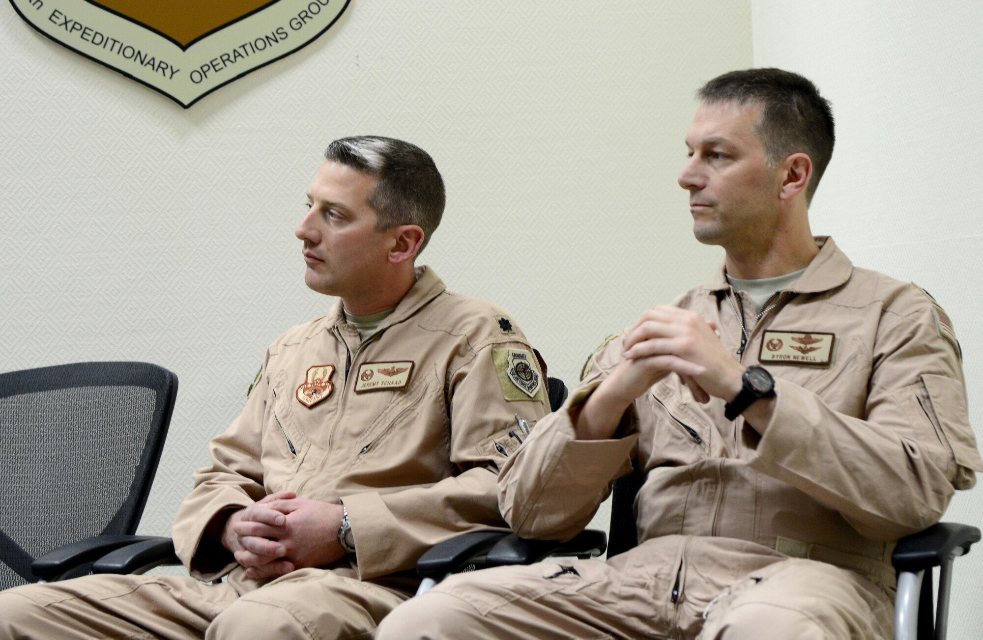 U.S. Air Force Lt. Cols. Jeremy Schaad, left, and Byron Newell listen to remarks from Col. Jim Dittus, 379th Expeditionary Operations Group commander, during a change of command ceremony, March 1, 2015, at Al Udeid Air Base, Qatar. During the ceremony, Newell assumed command of the 746th Expeditionary Airlift Squadron from Schaad. (U.S. Air Force photo by Senior Airman Kia Atkins)