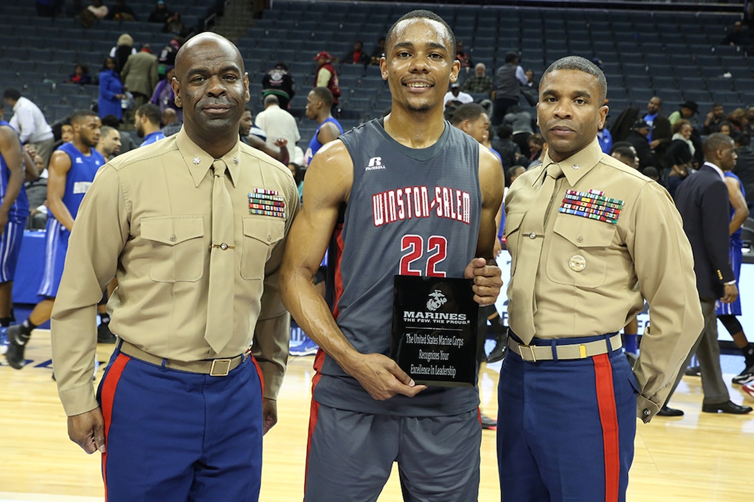 Lt. Col. Ricardo Player and Lt. Col. Dennis Hart present WyKevin Bazemore of Winston-Salem State Rams with the Excellence in Leadership Award after the women’s semi-final game of the Central Intercollegiate Athletic Association (CIAA) Basketball Tournament, in the Time Warner Arena on Feb. 27, 2015. The Marine Corps awards players from the winning team that show persistence and leadership on and off the court. Marines are present at the CIAA to promote awareness and education of Marine Corps opportunities. (Official Marine Corps photo by Cpl. John-Paul Imbody)