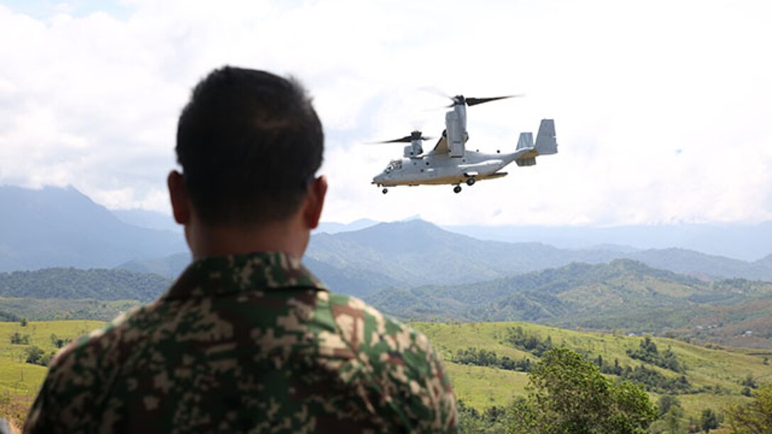 A member of the Malaysian Armed Forces watches as an MV-22B Osprey loaded with U.S. Marines approaches a landing zone Feb. 27 during a theater security cooperation event. The Marines are with Battalion Landing Team 2nd Battalion, 4th Marines, and Marine Medium Tiltrotor Squadron 262, 31st Marine Expeditionary Unit, and are currently conducting the annual Spring Patrol of the Asia-Pacific region.
