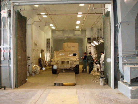 Letterkenny Army Depot painters prepare to de-mask a freshly painted ground mobility vehicle (GMV) inside a paint booth similar to the booths being upgraded as part of a $43 million project to make improvements to the infrastructure on the depot. The GMV was road tested prior to going through the final paint process. The upgrades will allow paint to adhere to the asset more efficiency and across the entire asset in one paint cycle. Some booths are receiving an infrared drying system (IR). Other booths will be retrofitted with gas fired elevated temperature systems to maintain maximum capacity inside the booth. 
