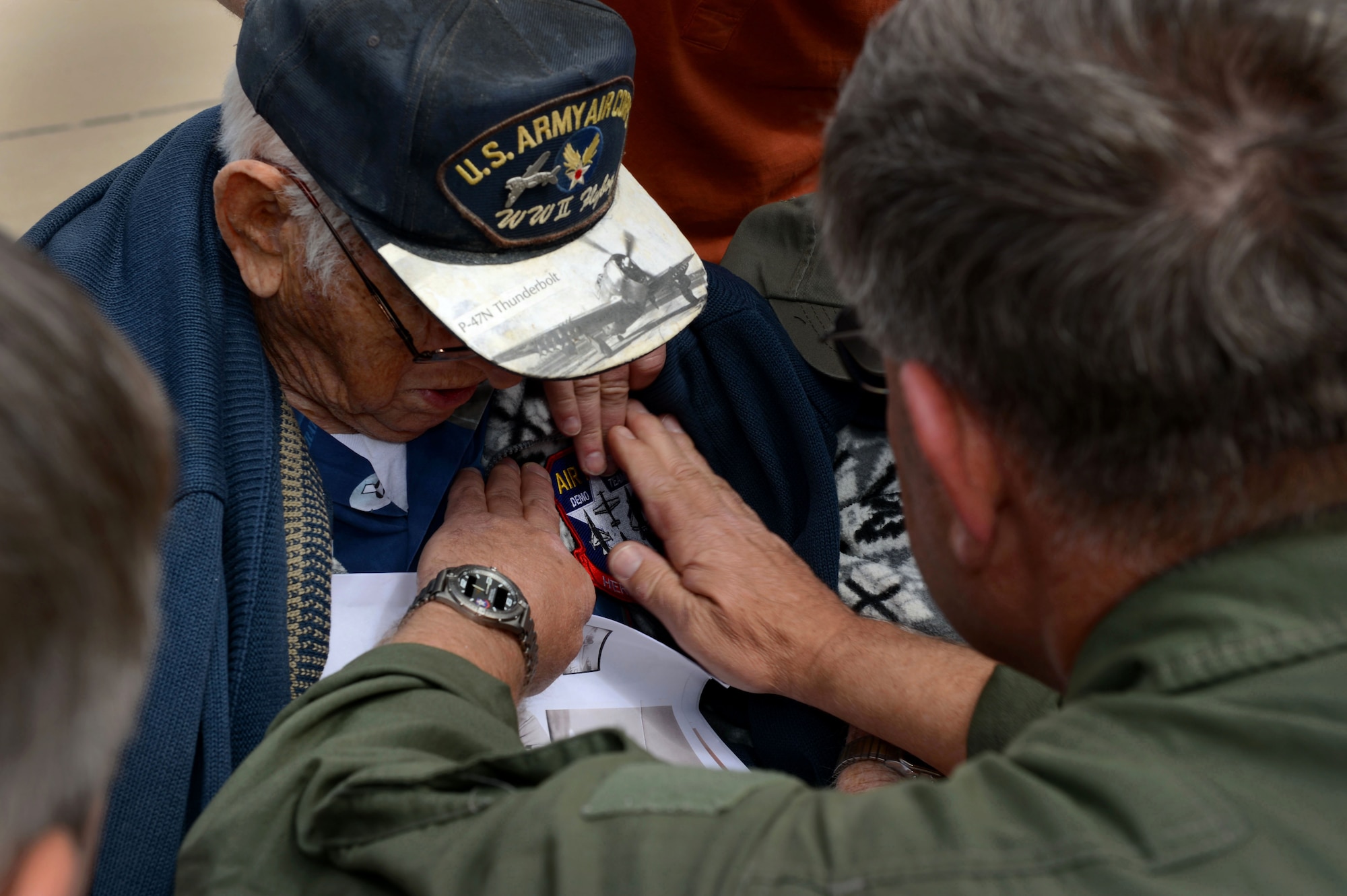 Retired Air National Guard Chief Warrant Officer 2 Robert Hertel, receives a Heritage Flight patch from Tom Gregory, P-47 Thunderbolt HF pilot during the Heritage Flight Training and Certification Course Feb. 28, 2015, at Davis-Monthan Air Force Base, Ariz. Hertel, a 92-year-old veteran, flew the Thunderbolt during World War II and had not seen one since his retirement in the 1960's. (U.S. Air Force photo/Senior Airman Jensen Stidham)