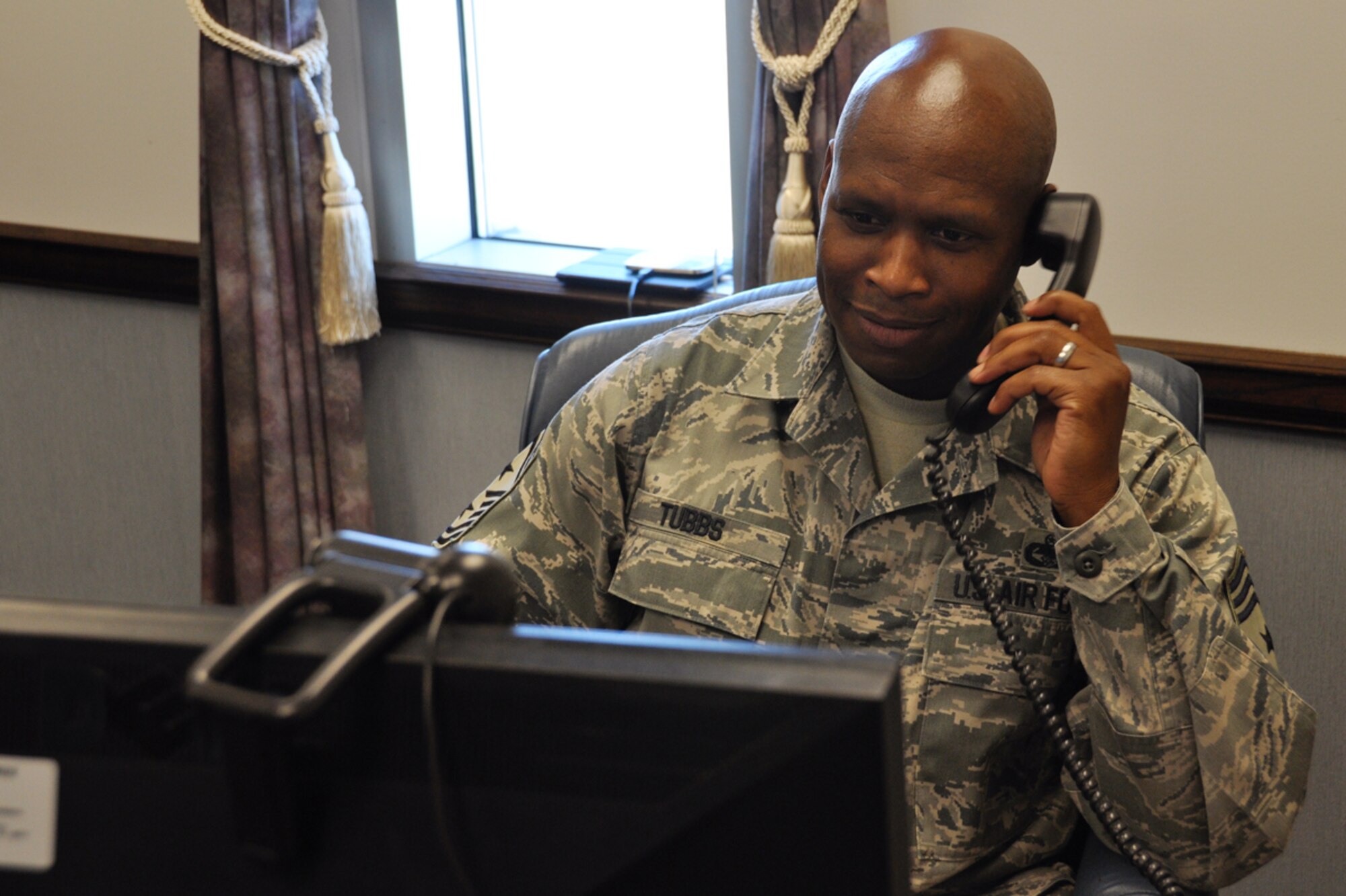 Chief Master Sgt. Lyndon Tubbs, 94th Airlift Wing command chief, answers a phone call at Dobbins Air Reserve Base, Ga. Feb. 8, 2015. Tubbs brings with him an immense amount of experience, and a motivation to help Airmen succeed. (U.S. Air Force photo/Senior Airman Miles Wilson)