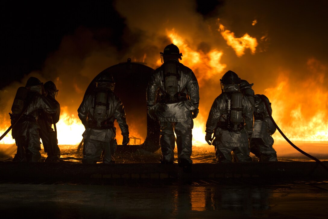 Marines use water to extinguish a fuel fire at Marine Corps Air Station Futenma during live-burn training Feb. 21. Bulk fuel specialists dispensed fuel into the training pit, and a Marine with Aircraft Rescue Firefighting ignited the fluid. The ARFF and bulk fuel specialist Marines then worked together to contain and extinguish the fire while enhancing communication and teamwork. The Marines are with ARFF, Headquarters and Headquarters Squadron, MCAS Futenma, as well as Bulk Fuel Company, 9th Engineer Support Battalion, 3rd Marine Logistics Group, III Marine Expeditionary Force.