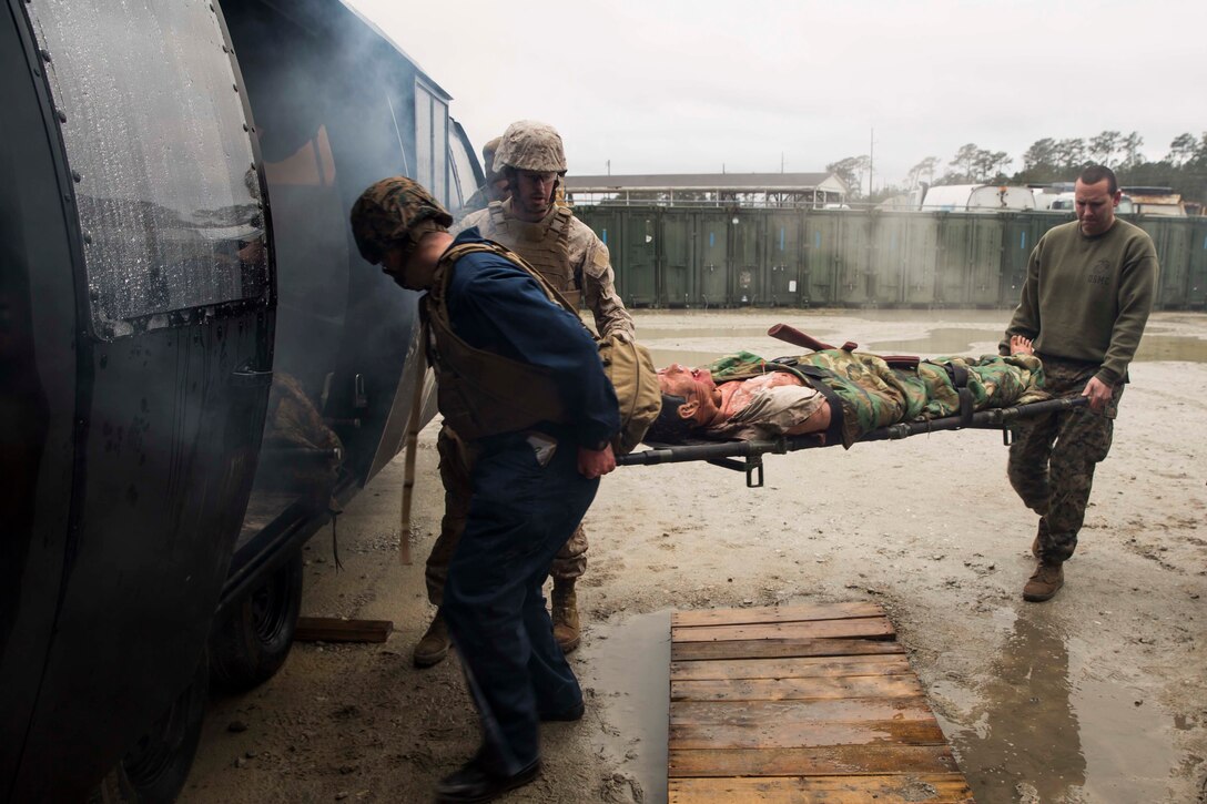 Field medical service technicians with 2nd Medical Battalion, 2nd Marine Logisitics Group, load a simulated casualty into an aircraft during the culminating event for a week-long Tactical Combat Casualty Care course aboard Marine Corps Base Camp Lejeune, N.C., Feb. 26, 2015. The course included classes that covered major hemorrhaging, airway control in field settings, assessment of a patient, how to treat burn patients, head injuries and hypothermia. (U.S. Marine Corps photo by Cpl. Krista James/ Released)