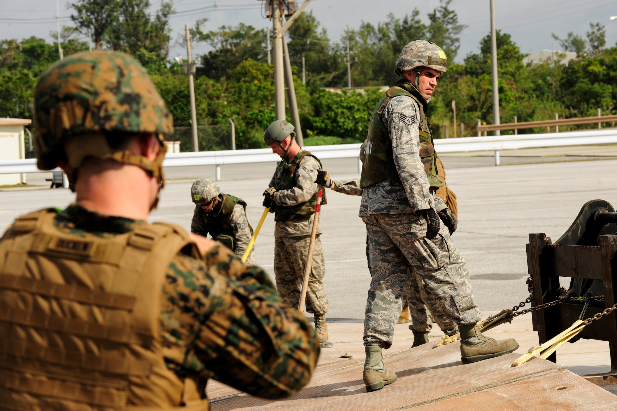 U.S. Air Force Staff Sgt. Matthew Hochstein, 18th Civil Engineering Squadron structural craftsman spots a forklift at Kadena Air Base, Japan Feb. 26, 2015.  Hochstein demonstrated how to properly unfold the fiberglass mat to Marines from the 172nd and 171st Engineering Companies during a joint airfield damage and repair contingency exercise. (U.S. Air Force photo by Airman 1st Class John Linzmeier)