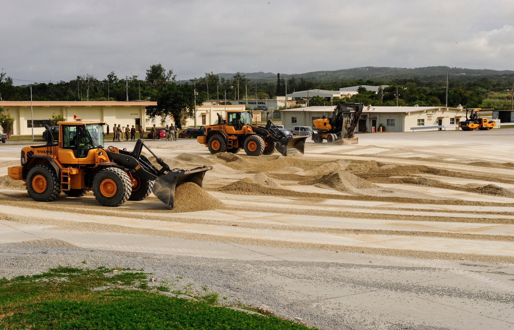 Loaders operated by 18th Civil Engineer Group Airmen level out a 50 foot crater on a mock runway at Kadena Air Base, Japan Feb. 26, 2015. Marines from 172nd and 171st Engineering Companies participated in a joint airfield damage and repair contingency exercise to learn how civil engineer Airmen respond to airfield damage and to strengthen joint capabilities of reestablishing an operational runway. (U.S. Air Force photo by Airman 1st Class John Linzmeier)