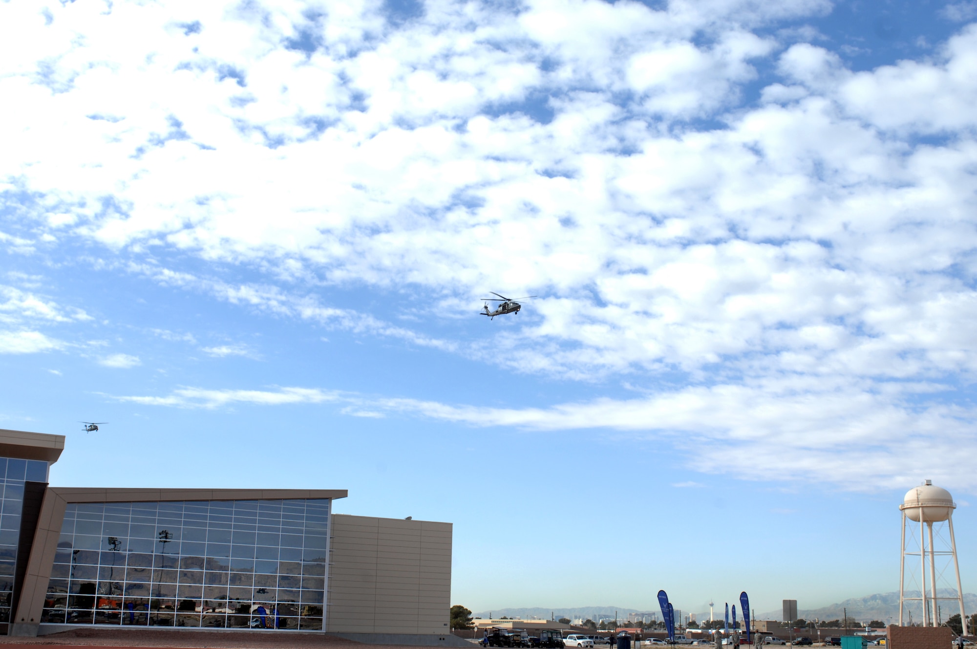 Two HH-60G Pave Hawks fly over the Warrior Fitness Center during the 2015 U.S. Air Force Trials opening ceremony at Nellis Air Force Base, Nev., Feb. 27, 2015. The opening ceremony signified the official start of the Air Force Trials at Nellis AFB, which will run Feb. 27 to March 5. (U.S. Air Force photo by Staff Sgt. Jack Sanders)