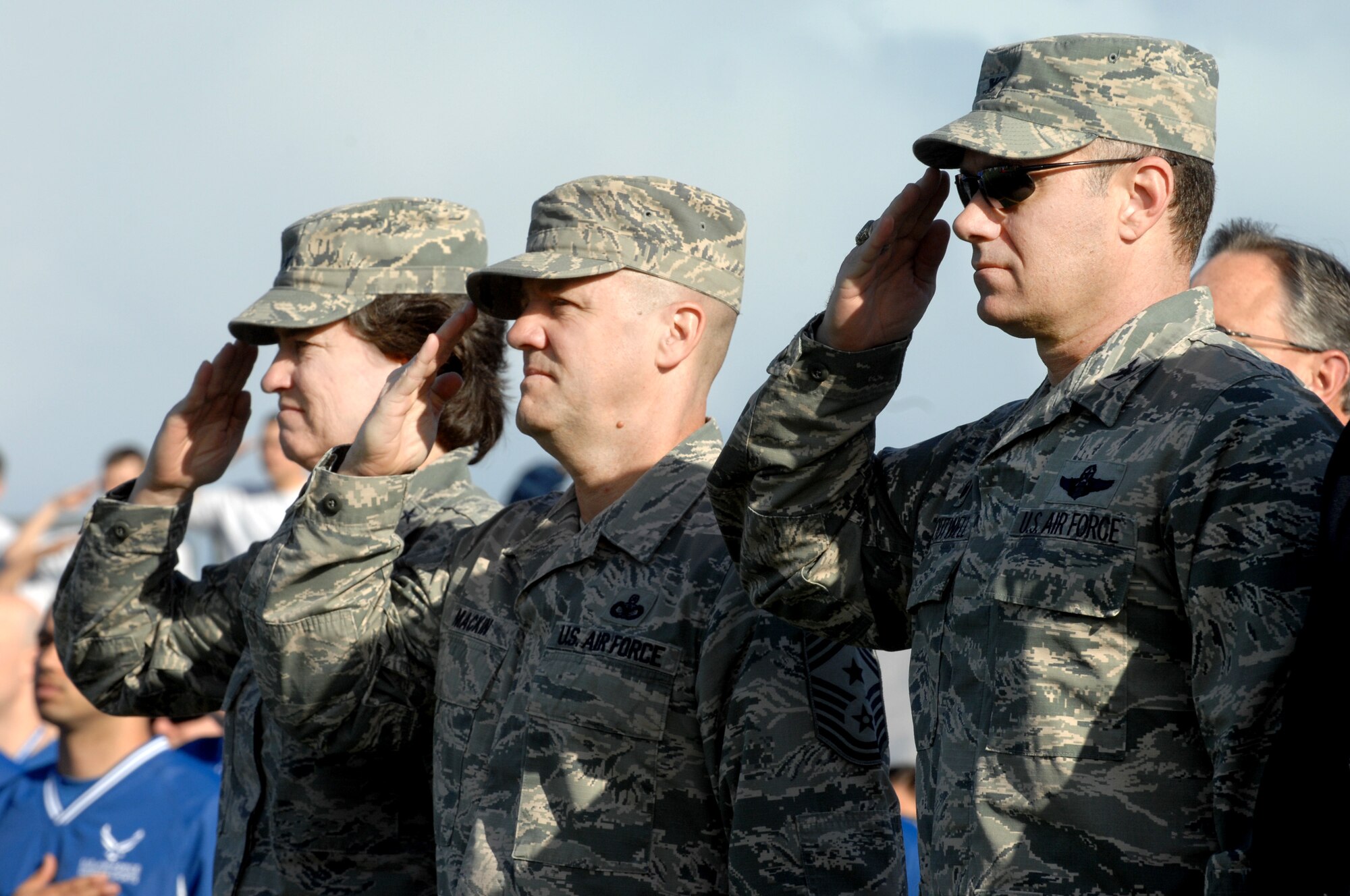 (From left to right) Maj. Gen. Margaret Poore, Air Force Personnel Center commander, Chief Master Sgt. Deno Mackin, AFPC command chief, and Col. Richard Boutwell, 99th Air Base Wing commander, salute during the national anthem at the 2015 U.S. Air Force Trials opening ceremony at Nellis Air Force Base, Nev., Feb. 27, 2015. The 2015 Air Force Trials marks the second occurrence of the trials and the second time Nellis AFB has hosted the event. (U.S. Air Force photo by Staff Sgt. Jack Sanders)