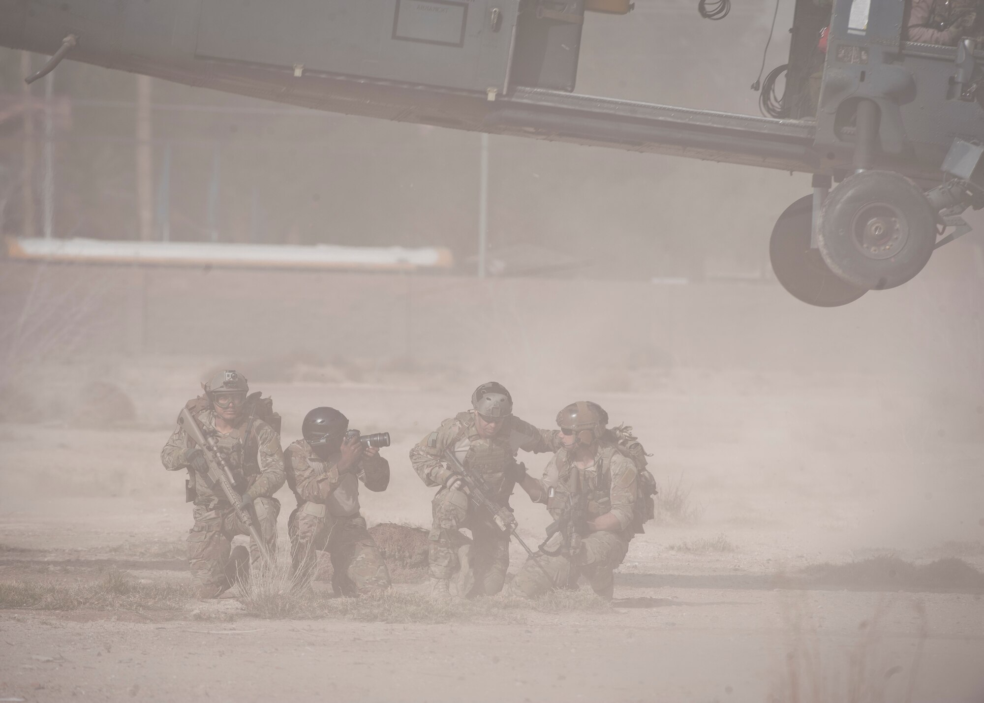Pararescuemen from the 58th Rescue Squadron and a photojournalist from the 3rd Combat Camera Squadron wait for an HH-60G Pave Hawk to depart prior to moving toward the opening ceremony of the 2015 Air Force Trials at Nellis Air Force Base, Nev., Feb. 27, 2015. The pararescuemen were carrying an Air Force Wounded Warrior flag that was to be delivered to the ceremony’s keynote speaker, Maj. Gen. Margaret Poore, Air Force Personnel Center commander. (U.S. Air Force photo by Staff Sgt. Siuta B. Ika)