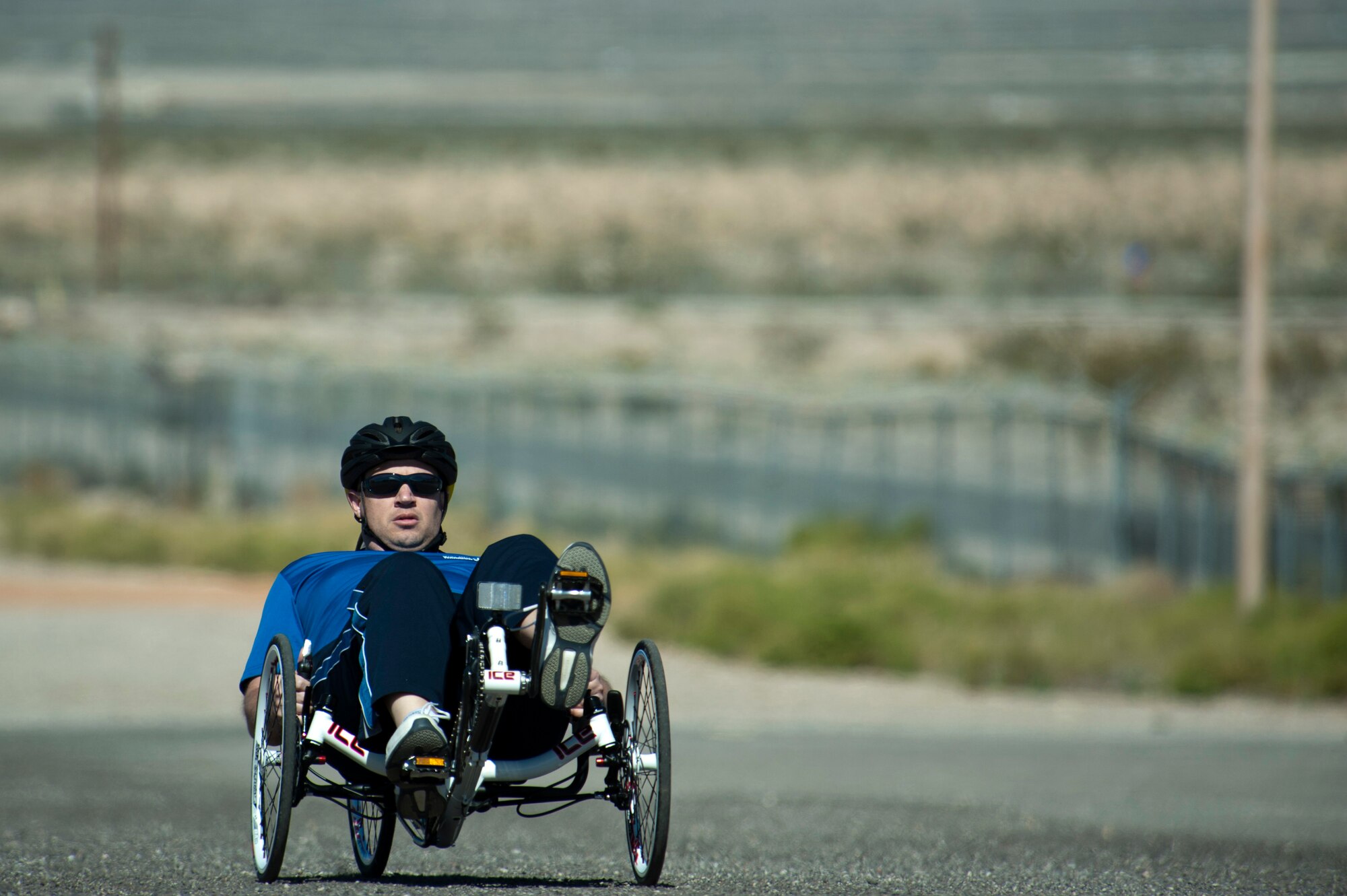 Ryan Delaney, 2015 U.S. Air Force Trials cycling team member, peddles across a parking lot to test a newly-adjusted bike during a cycling fitting session at Nellis Air Force Base, Nev., Feb. 26, 2015. Service members are participating in adaptive athletic reconditioning for lasting effects on physical and emotional recovery. (U.S Air Force photo by Senior Airman Timothy Young)
