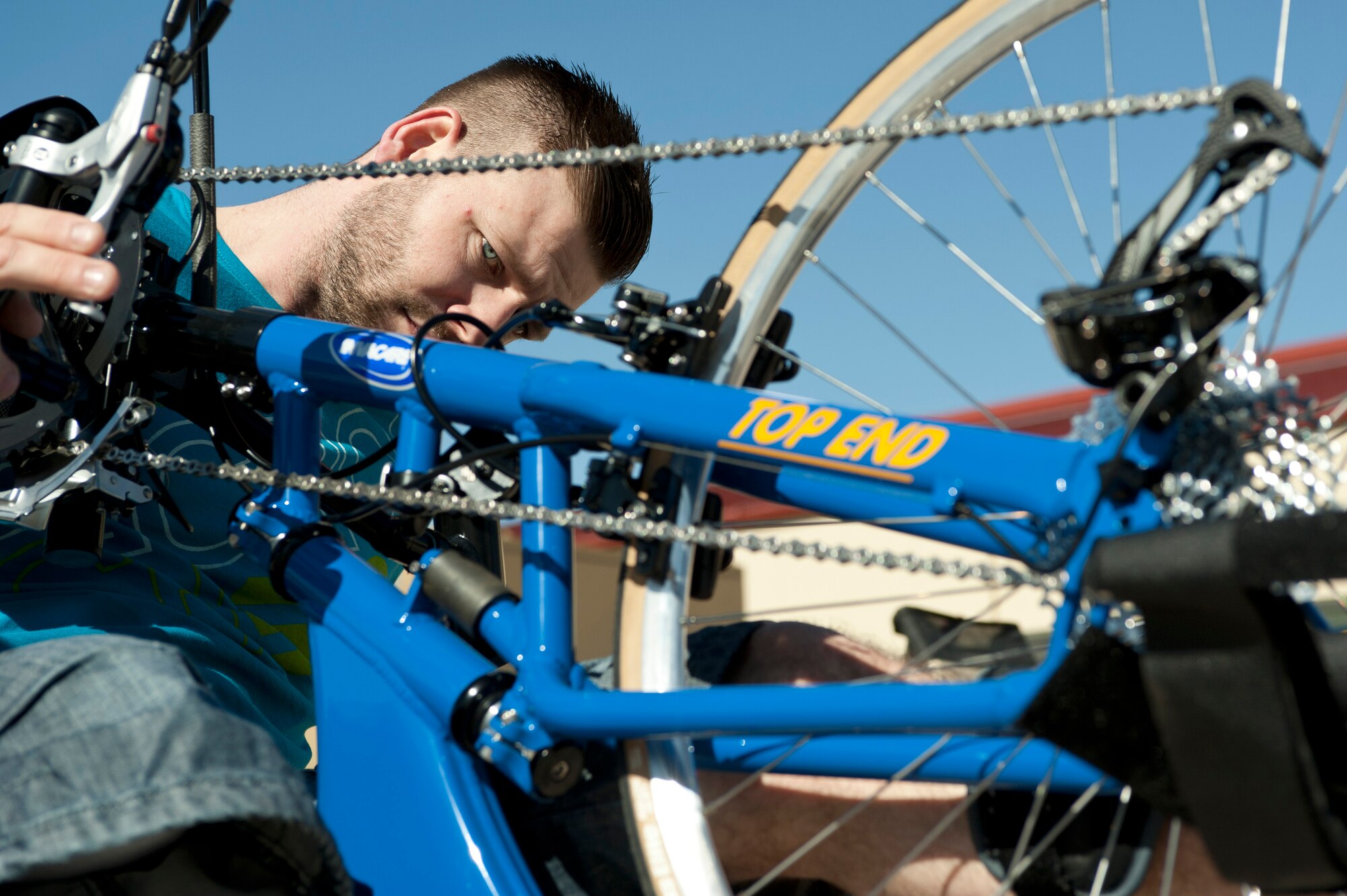 Garith Golightly, 2015 Help for Heroes cycling team member, checks his bike’s brakes during a cycling fitting session at Nellis Air Force Base, Nev., Feb. 26, 2015. Other sporting events during the trials include wheelchair basketball, wheelchair rugby, sitting volleyball, track and field, air pistol and rifle shooting, archery and swimming. (U.S Air Force photo by Senior Airman Timothy Young)
