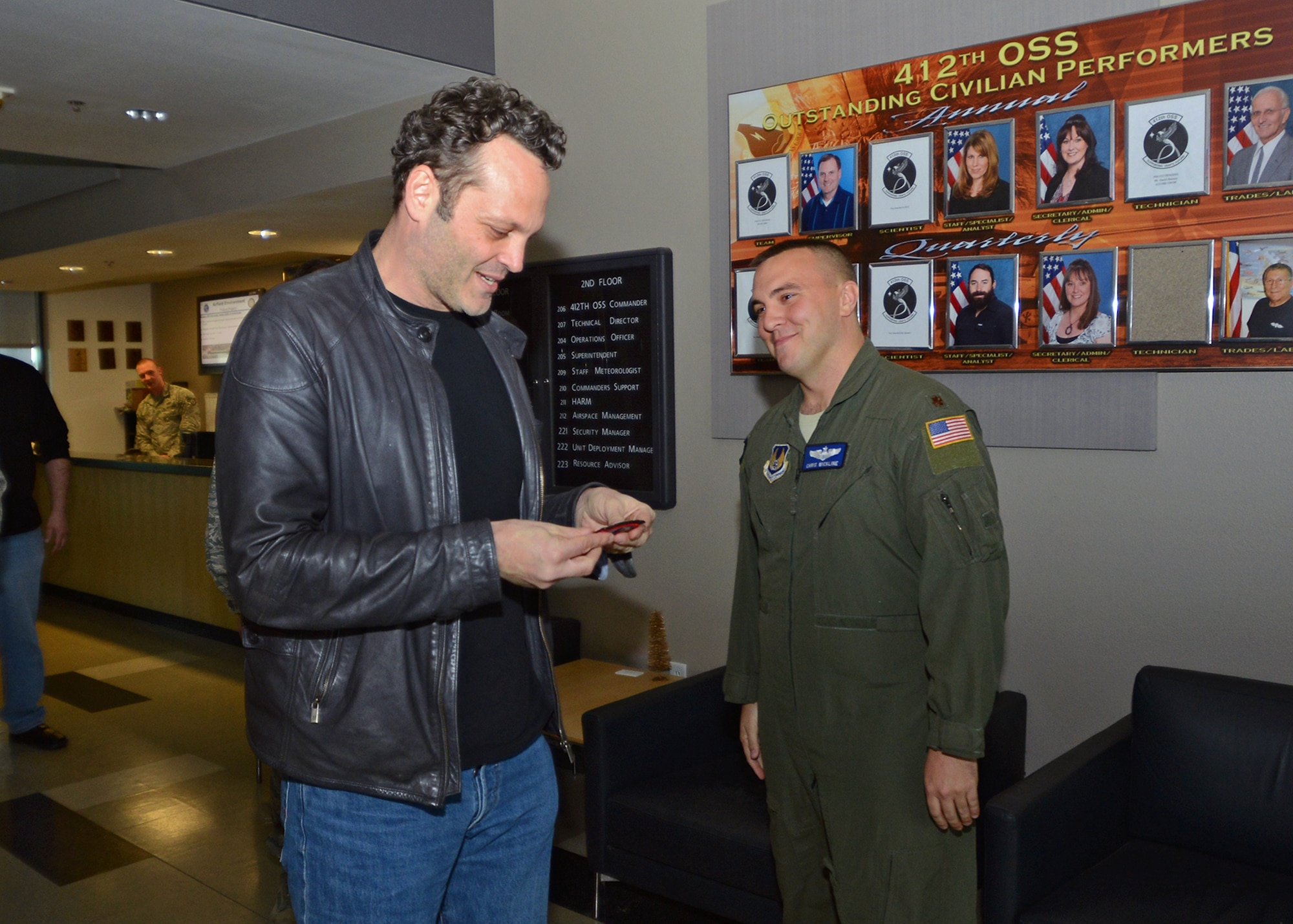 Actor Vince Vaughn receives a U.S. Air Force Test Pilot School patch with the Average Joe's logo from Vaughn's movie, "Dodgeball," from Maj. Chris Wickline, 412th Operations Support Squadron Assistant Director of Operations, Feb. 28 at Edwards. During Vaughn’s visit to Edwards, he met with Airmen and their families and introduced an advance screening of his new movie, "Unfinished Business," at the base theater as part of his third USO tour. (U.S. Air Force photo by Jet Fabara)