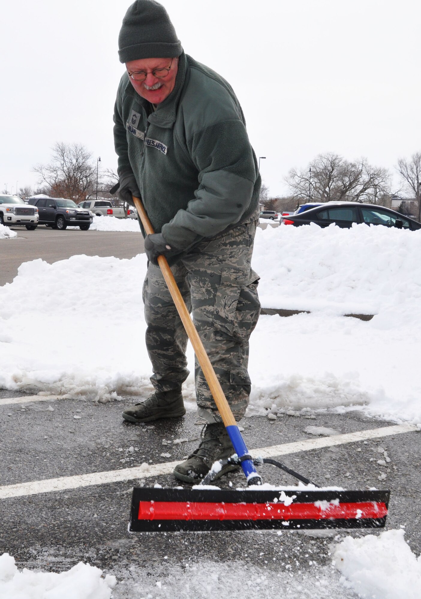Senior Master Sgt. Jeff Kilian, 931st Air Refueling Group Logistics Management Specialist, clears the ice and snow from the entry way to the 931st ARG Headquarters Building at McConnell Air Force Base, Kan., March 2, 2015.  Heavy snows over the past weekend resulted in more than 2 inches of snow at McConnell and the local area.  (U.S. Air Force photo by Tech. Sgt. Abigail Klein)