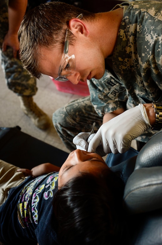 U.S. Army Capt. Michael Sullivan, Joint Task Force-Bravo Medical Element Dentist, extracts a tooth from a young girl during a Medical Readiness Training Exercise in La Blanca, Guatemala, Feb. 26, 2015.  Together JTF-Bravo, the Guatemalan Ministry of Health and members of the Guatemalan military came together to help provide medical care to over 1,200 Guatemalan citizens in need. During the two-day exercise, the JTF-Bravo team and preventative medicine specialists from the Guatemalan Ministry of Health educated, screened and treated over 1,200 patients. (U.S. Air Force Photo/Tech. Sgt. Heather Redman)