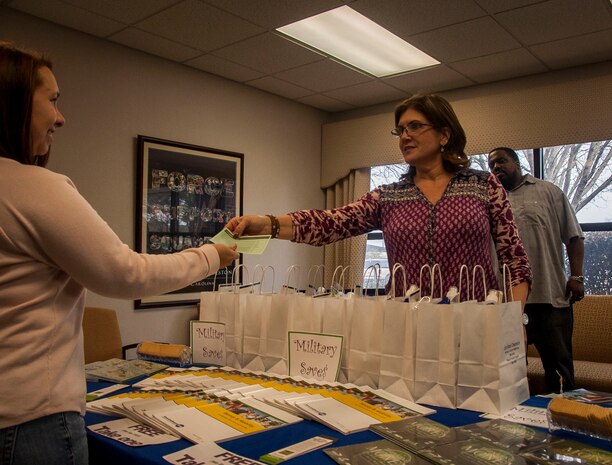 Barbra Lang, Airman & Family Readiness Center community readiness consultant, hands Military Saves brochure information to Nicole Gibbs, military spouse, Feb. 27, 2015 at the Joint Base Charleston – Air Base, S.C. Military Saves, a component of America Saves and a partner with the Department of Defense Financial Readiness Campaign, is a research based social marketing campaign intended to motivate, support and encourage military families to save money and build wealth. The chairman of the joint chiefs of staff asked each service member to support Military Saves Week, designated from Feb. 23 through 28. This year at JB Charleston, the AFRC partnered with the Fleet and Family Center for a total force initiative toward financial readiness. (U.S. Air Force photo / Senior Airman Tom Brading) 
