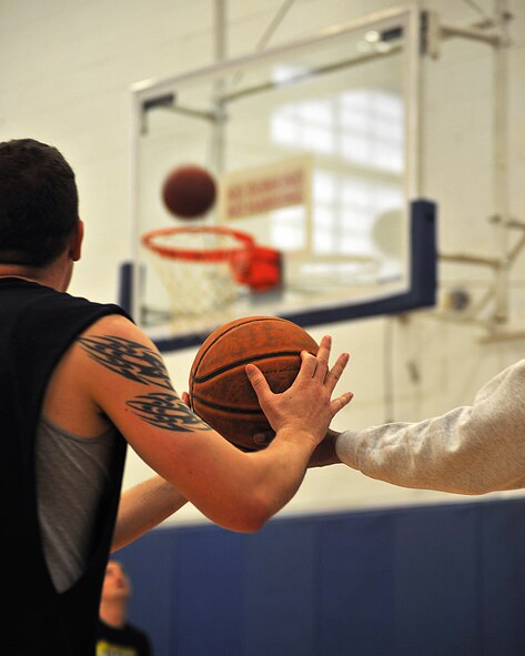 Staff Sgt. Thomas Spencer, 69th Maintenance Squadron maintenance scheduler, takes a basketball and prepares to shoot during the hot shots event at the 2015 Winter Bash, Feb. 26 on Grand Forks Air Force Base, N.D. The 69th MXS team came in third overall with 34 points. (U.S. Air Force photo/Senior Airman Xavier Navarro)