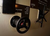 Two wheels adorn the blast door of the Oscar 1 missile alert facility near Mohall, N.D., Jan. 9, 2015. The wheel on the left works like a locking mechanism, while the wheel on the right, controls the doors internal bolts that feed into the adjacent wall. (U.S. Air Force photo/Senior Airman Stephanie Morris)