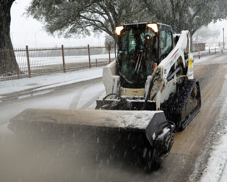 The 2nd Civil Engineer Squadron dirt boys keep the roads as clean and safe as possible during a winter storm on Barksdale Air Force Base, La., Feb. 25, 2015. The CES Airmen used a loader, kick brooms, two Bobcats and a sander to scrape ice off of base roads, bridges, and gates. (U.S. Air Force photo/Senior Airman Benjamin Raughton)