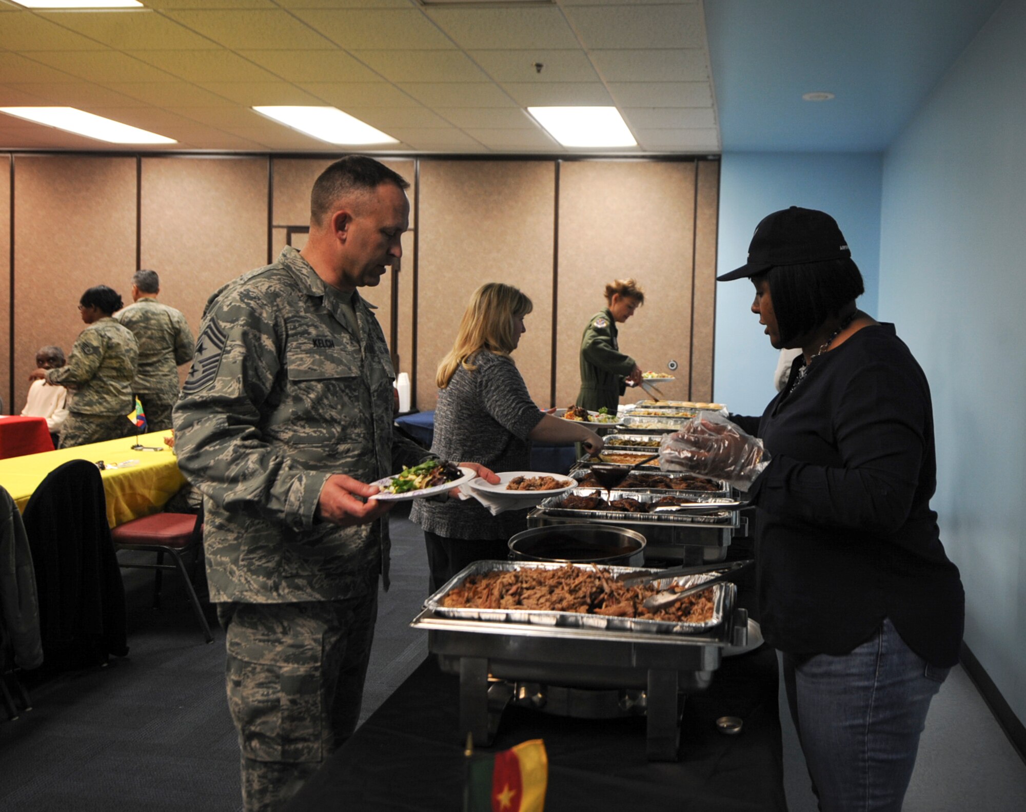 Onjel Gambrell, 23d Civil Engineer Squadron secretary, serves food to U.S. Air Force Chief Master Sgt. David Kelch, 23d Wing command chief, during the Black History Month luncheon Feb. 27, 2015, at Moody Air Force Base, Ga. Members of the Black History Month committee organized the luncheon to celebrate the month. (U.S. Air Force photo by Senior Airman Olivia Bumpers/Released) 