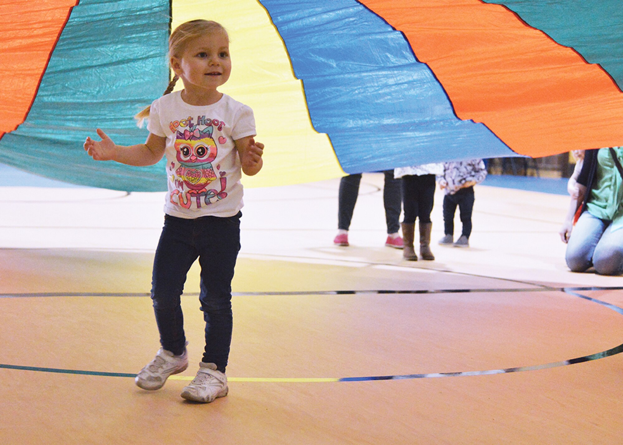 Sophie Fisher, 3, joins a group of kids who ran under a parachute during the "Start Smart Sports" event at Kirtland's Youth Center.  The program is designed to prepare small children for organized sports. (Photo by Todd Berenger)