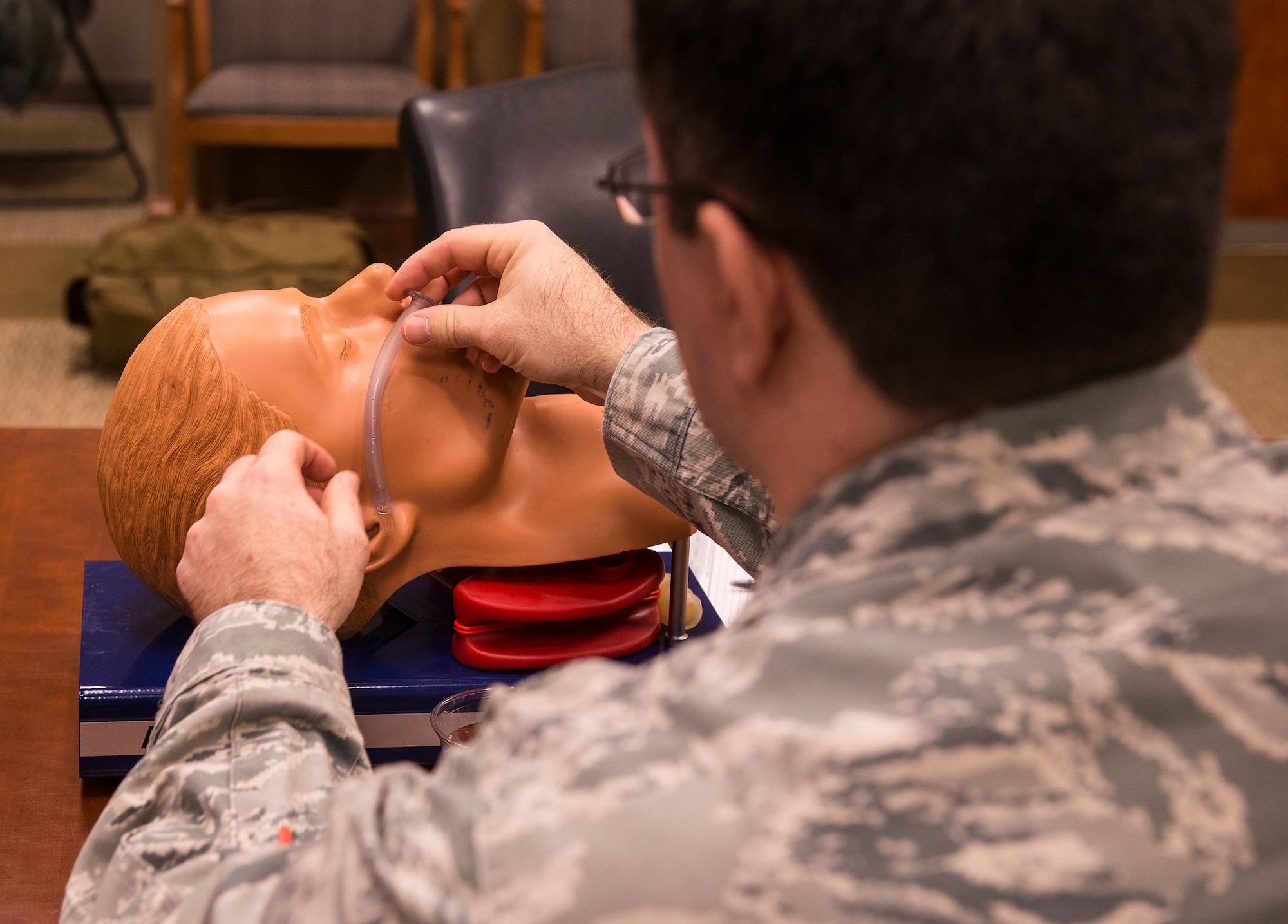 U.S. Air Force Lt. Col. Joshua Hughes, 23d Wing director of staff, measures a nasopharyngeal airway (NPA) during a self-aid and buddy care class Feb. 25, 2015, at Moody Air Force Base, Ga. The NPA is measured from the nose to the ear before it is inserted into the nose to ensure a proper fit. (U.S. Air Force photo by Airman 1st Class Ceaira Tinsley/Released)