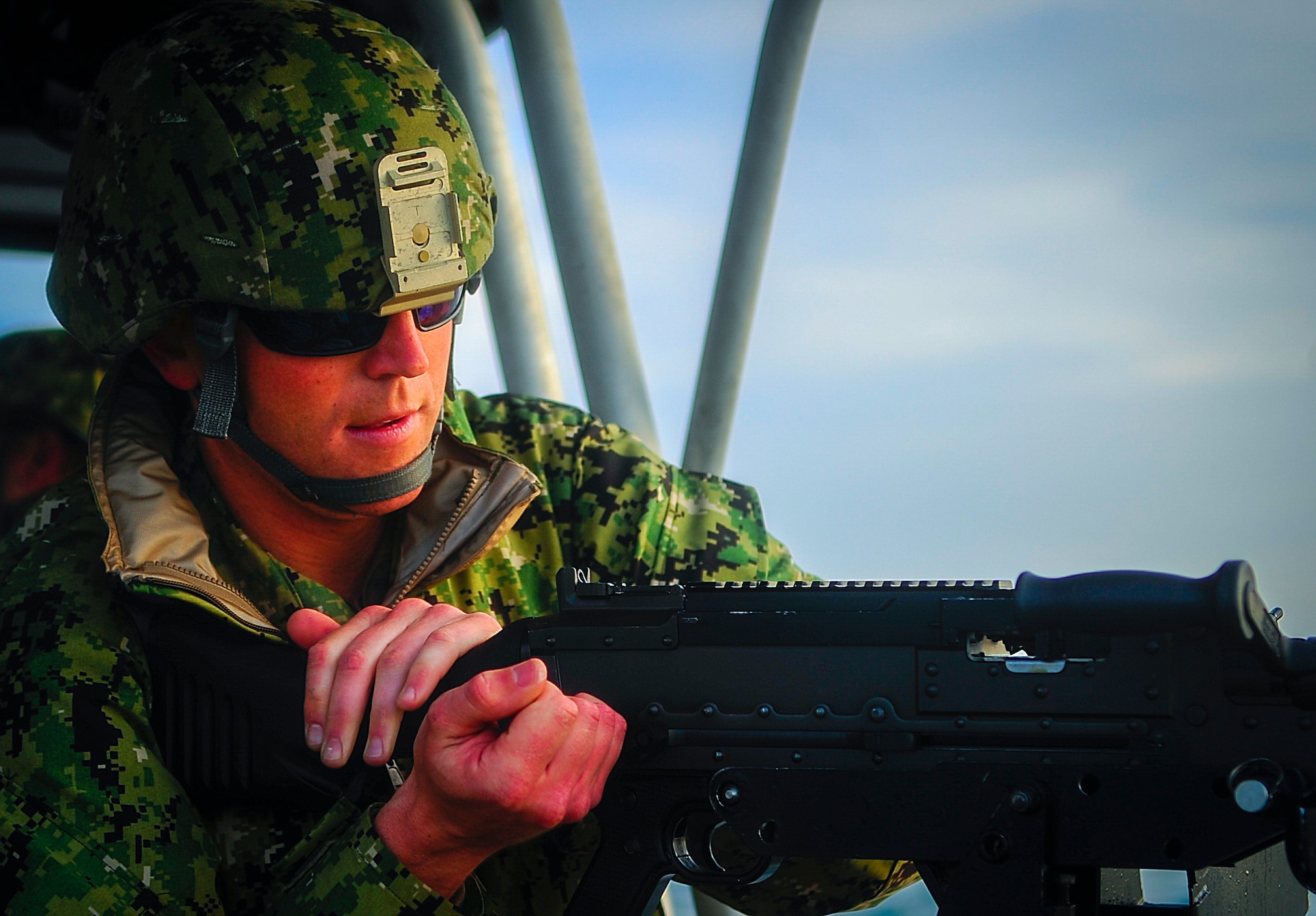 Petty Officer 3rd Class Kane Capone, a boatswain's mate stationed at PSU 309 in Port Clinton, Ohio, loads a M240 7.62 caliber machine gun on a port security boat in the Gulf of Mexico, Feb. 26, 2015. The PSU 309 is an elite Coast Guard Reserve task force with the unique mission of maintaining readiness to deploy within 96 hours of activation to active-duty status. (U.S. Air Force photo by Senior Airman Ned T. Johnston/Released)