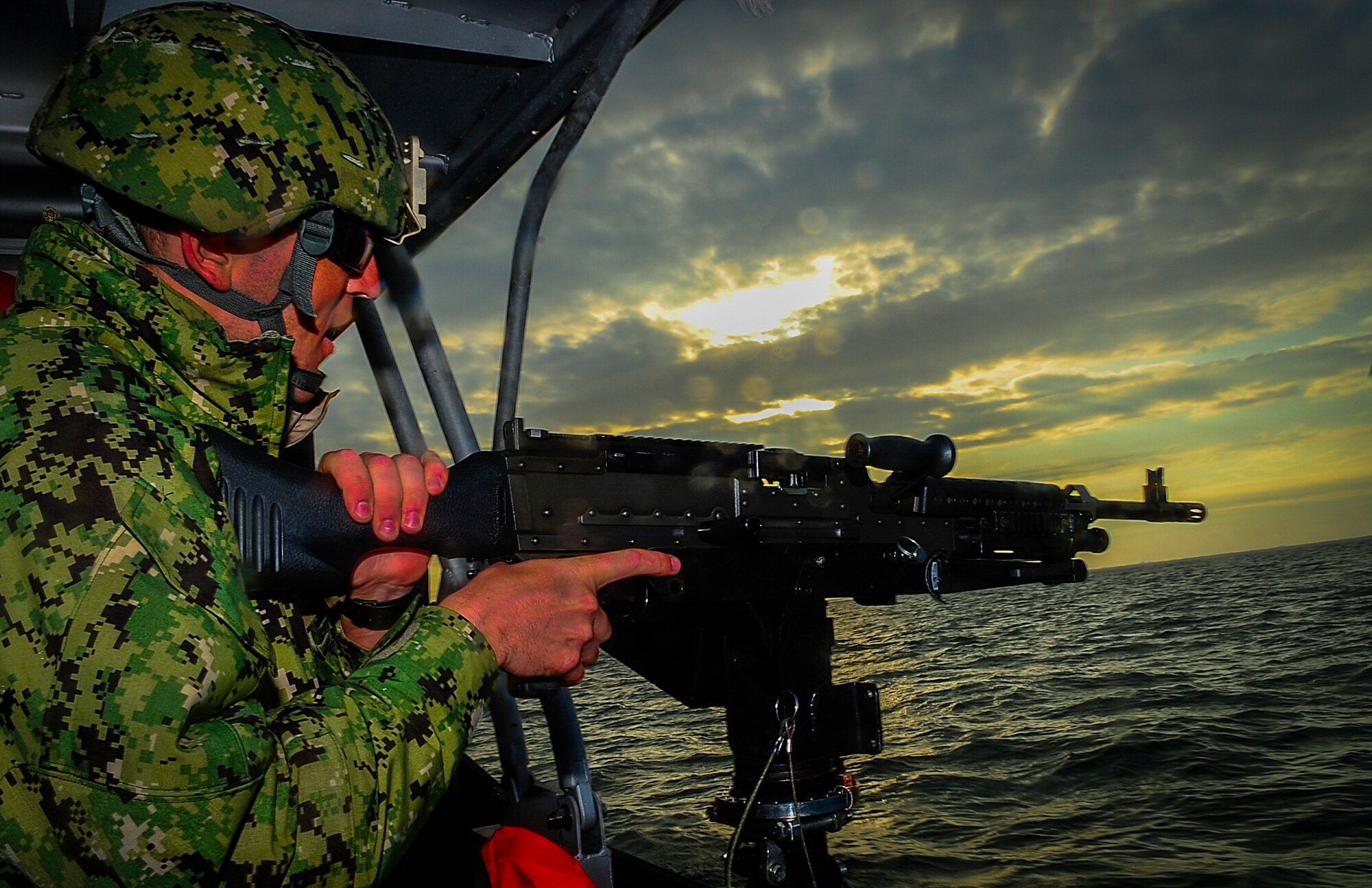 Petty Officer 3rd Class Kane Capone, a boatswain's mate stationed at PSU 309 in Port Clinton, Ohio, practices proper firing procedures on a starboard mounted M240 7.62 caliber machine gun in the Gulf of Mexico Feb. 26, 2015. The coastguardsmen with the Port Security Unit 309 have the unique mission of maintaining readiness to deploy within 96 hours of activation to active-duty status. (U.S. Air Force photo by Senior Airman Ned T. Johnston/Released)