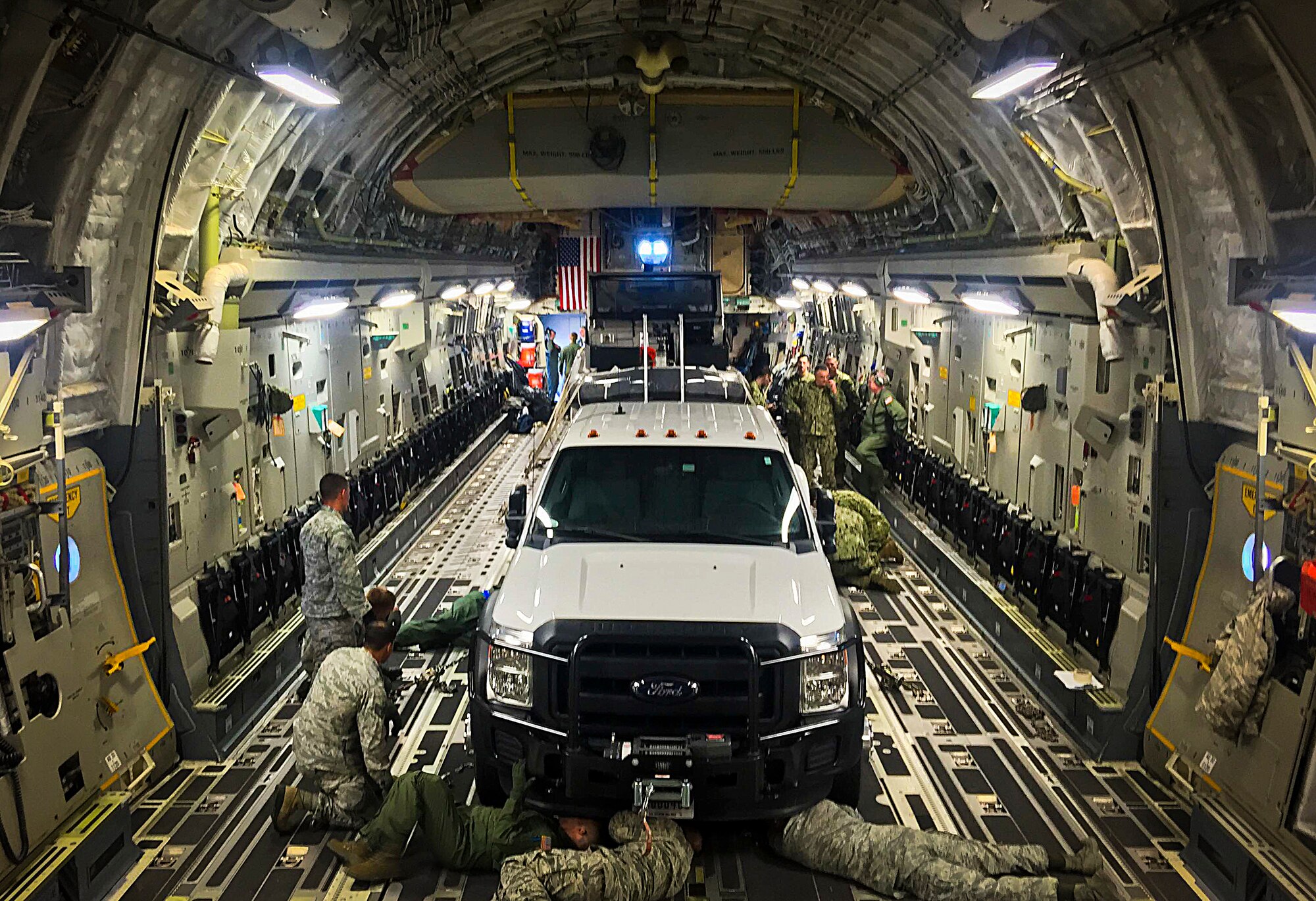 Airmen and coastguardsmen secure a 32-foot transportable port security boat inside a C-17 Globemaster III during exercise Patriot Sands at MacDill Air Force Base, Fla., Feb. 20, 2015. The coastguardsmen with the Port Security Unit 309 have the unique mission of maintaining readiness to deploy within 96 hours of activation to active-duty status. (U.S. Air Force photo by Senior Airman Ned T. Johnston/Released)