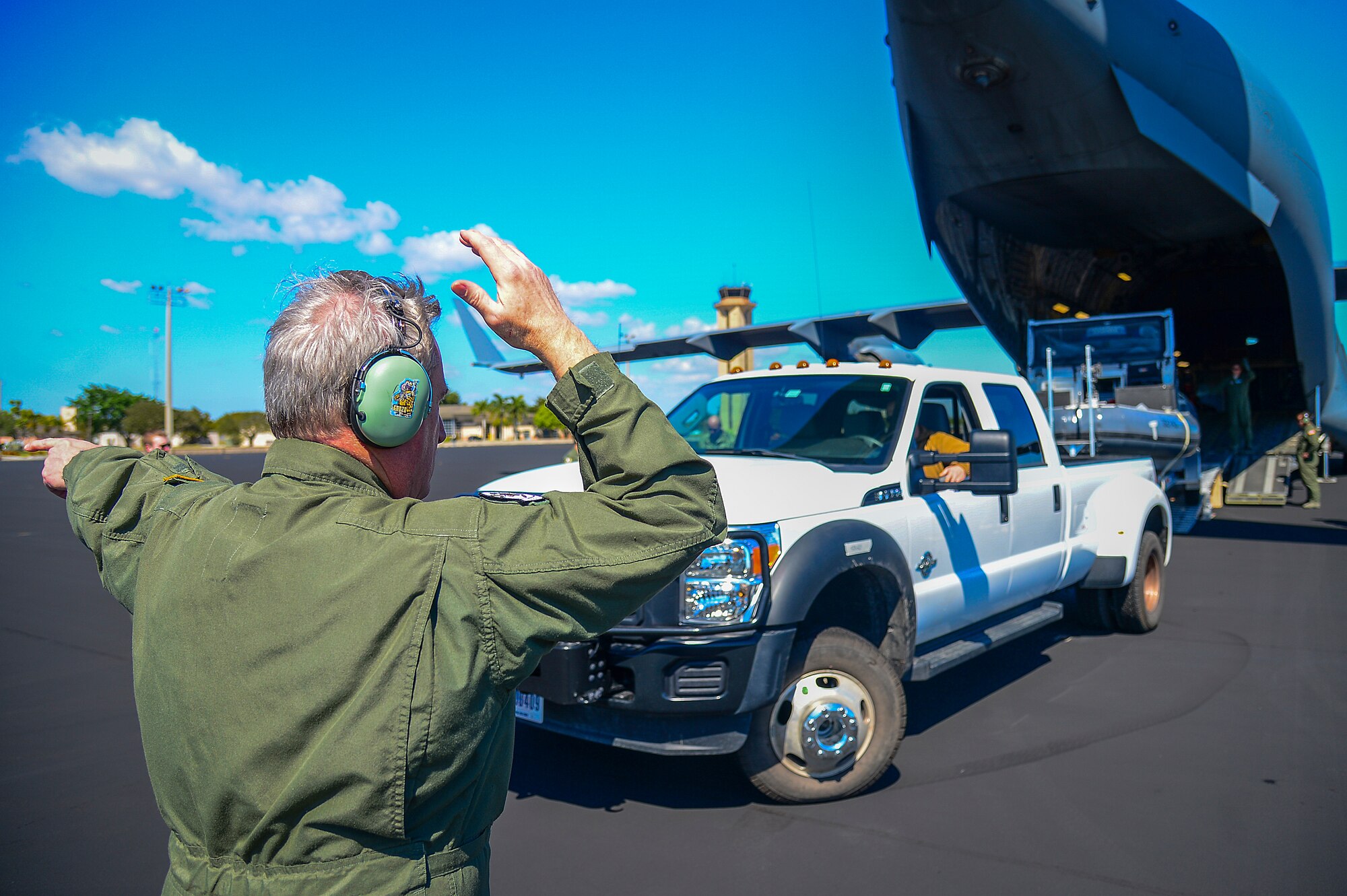 A senior master sergeant loadmaster marshals a Port Security Unit 309 transportable port security boat into a C-17 Globemaster III at Homestead Air Force Base, Fla., Feb. 20, 2015. The 309th “deployed” their unit to MacDill providing experience for their engineering and mobility crews, and Air Force loadmasters to load and transport equipment. (U.S. Air Force photo by Senior Airman Ned T. Johnston/Released)
