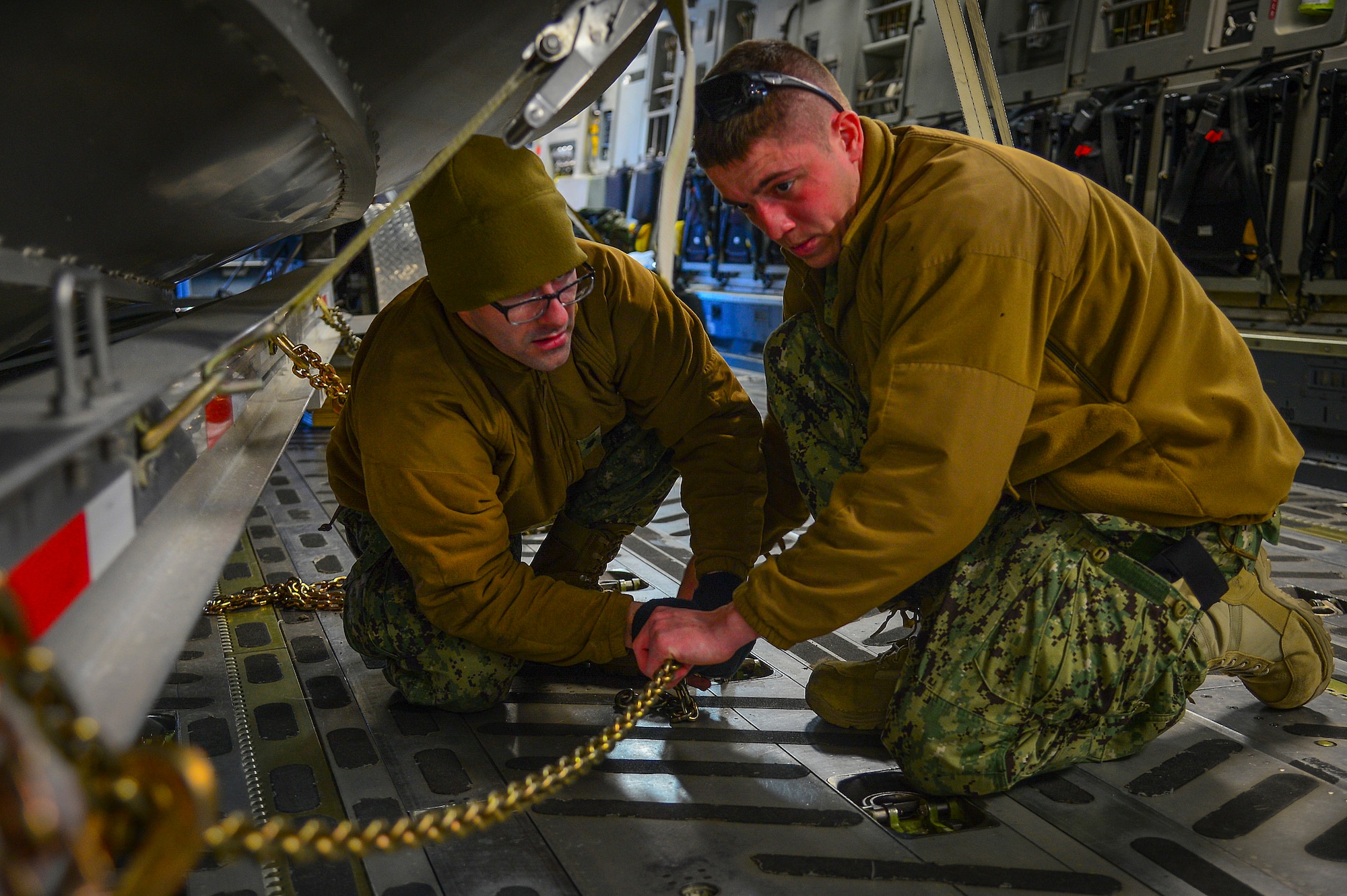 Petty Officer 2nd Class Matthew Farr (right), a machinery technician stationed at Port Security Unit 309 in Port Clinton, Ohio, and Petty Officer 2nd Class Andrew Gerspacher, a damage controlman stationed at PSU 309, secure a transportable port security boat to a C-17 Globemaster III at MacDill Air Force Base, Fla., Feb. 20, 2015. The 309th “deployed” their unit to MacDill providing experience for their engineering and mobility crews, and Air Force loadmasters to load and transport equipment. (U.S. Air Force photo by Senior Airman Ned T. Johnston/Released)