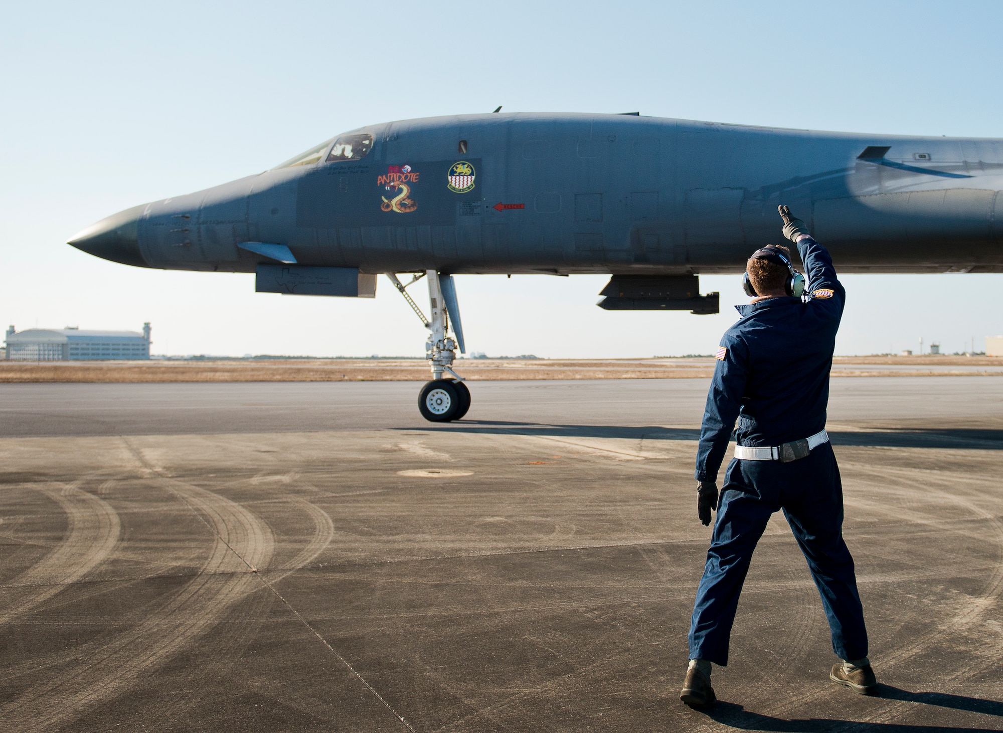 Senior Airman Sam Gearhart, 337th Test and Evaluation Squadron, waves goodbye after saluting the B-1B Lancer pilot as the aircraft begins taxiing Feb. 20 at Eglin Air Force Base, Fla.  The 53rd Wing bomber from Dyess AFB, Texas was here for a few missions and to allow wing personnel an opportunity to see one of their geographically separated aircraft up close. (U.S. Air Force photo/Samuel King Jr.)