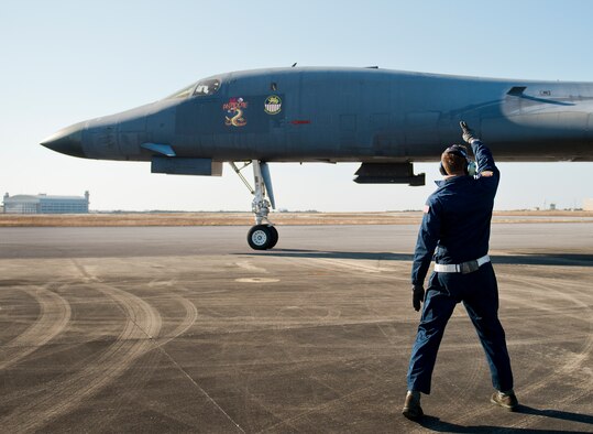 Senior Airman Sam Gearhart, 337th Test and Evaluation Squadron, waves goodbye after saluting the B-1B Lancer pilot as the aircraft begins taxiing Feb. 20 at Eglin Air Force Base, Fla.  The 53rd Wing bomber from Dyess AFB, Texas was here for a few missions and to allow wing personnel an opportunity to see one of their geographically separated aircraft up close. (U.S. Air Force photo/Samuel King Jr.)