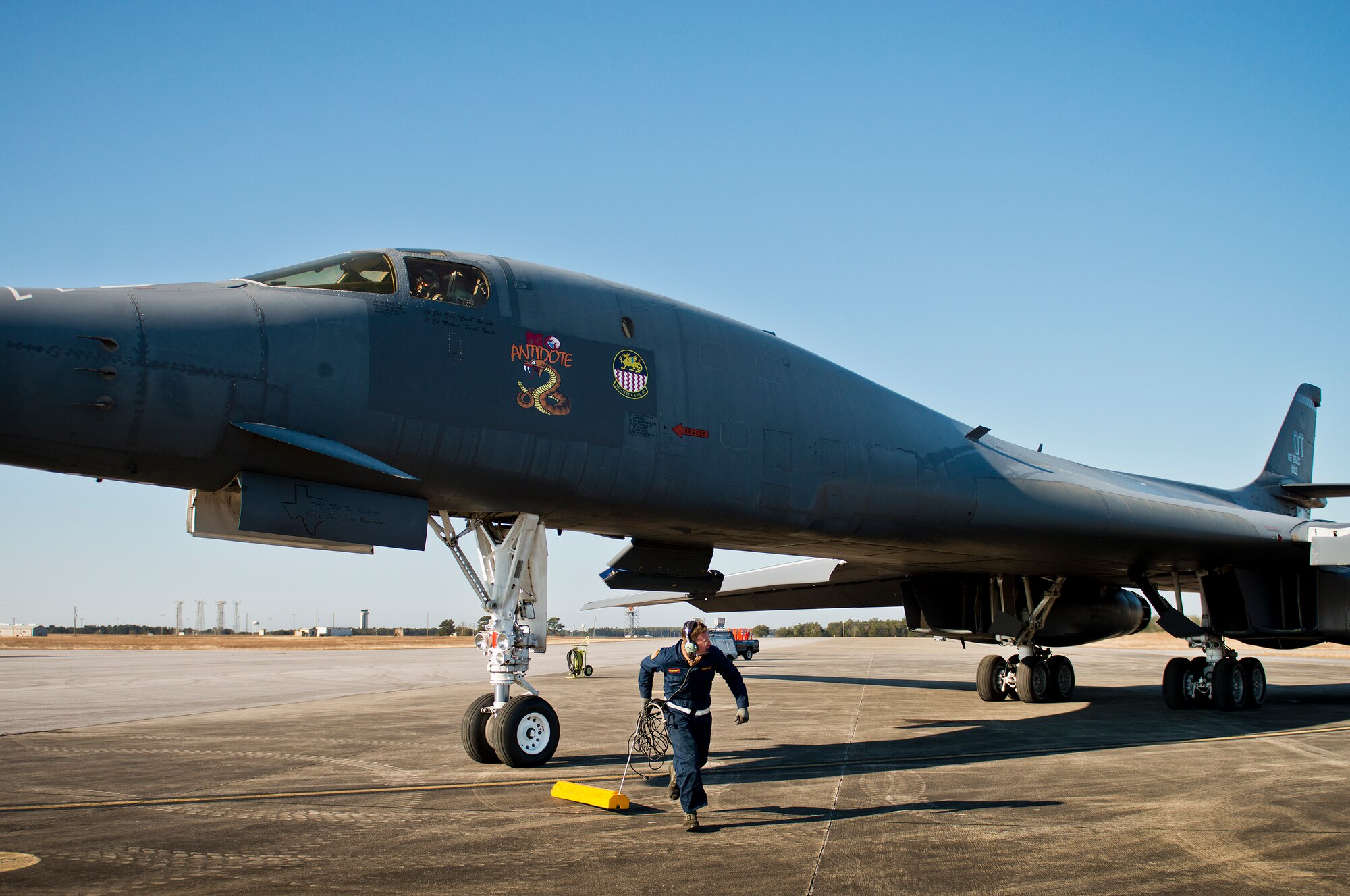 Senior Airman Sam Gearhart, 337th Test and Evaluation Squadron, pulls the chock prior to marshalling out the B-1B Lancer Feb. 20 at Eglin Air Force Base, Fla.  The 53rd Wing bomber from Dyess AFB, Texas was here for a few missions and to allow wing personnel an opportunity to see one of their geographically separated aircraft up close. (U.S. Air Force photo/Samuel King Jr.)