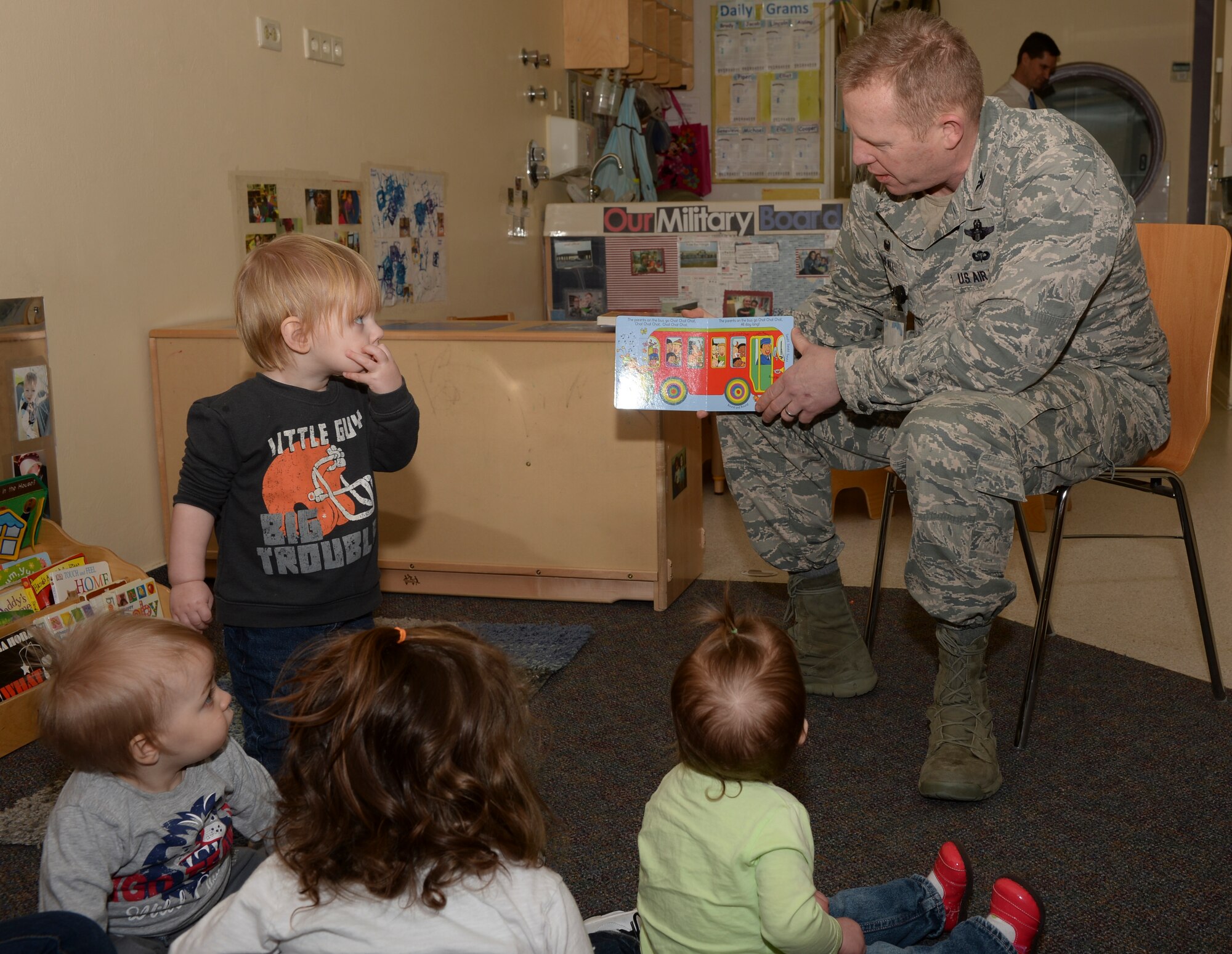U.S. Air Force Col. Joe McFall, 52nd Fighter Wing commander, reads to children during a Read Across America event at a child development center at Spangdahlem Air Base, Germany, March 2, 2015. McFall read four books during the event, which aimed to foster an appreciation among children. (U.S. Air Force photo by Staff Sgt. Joe W. McFadden/Released)