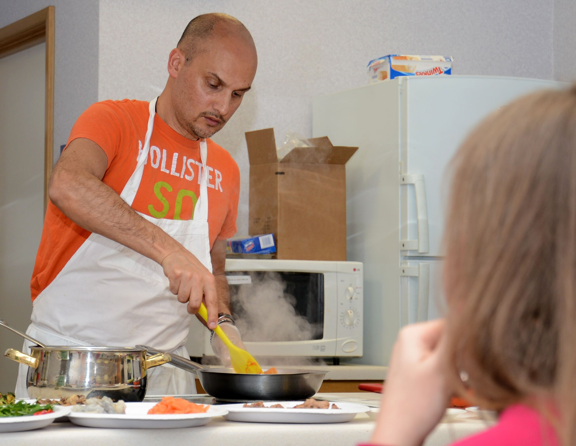 Salvatore Sivelli, explains how to cook a dish during an Italian cooking demonstration Feb. 26, 2015, in the Hardstand Fitness Center on RAF Mildenhall, England. Each month, the 100th Force Support Squadron hosts a free cooking class teaching base members how to cook healthy meals. (U.S. Air Force photo by Gina Randall/Released)