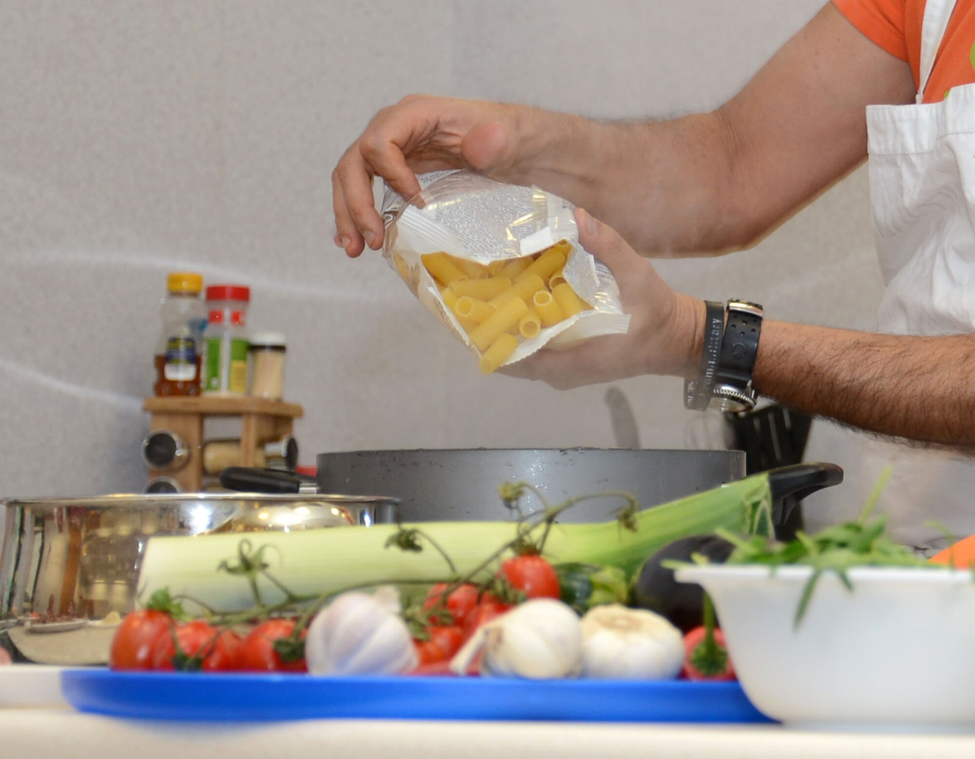 Salvatore Sivelli, a contractor, adds ingredients to a dish during an Italian cooking demonstration Feb. 26, 2015, in the Hardstand Fitness Center on RAF Mildenhall, England. Each month, the 100th Force Support Squadron hosts a free cooking class that teaches base members how to cook healthy meals. (U.S. Air Force photo by Gina Randall/Released)
