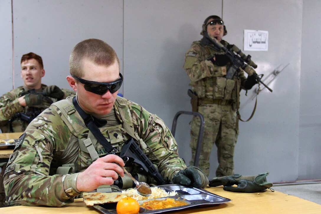 A U.S. soldier eats a lunch of rice, beans, meat, bread and fruit during a visit to the regional police logistics center in Nangarhar province, Afghanistan, Feb. 17, 2015.