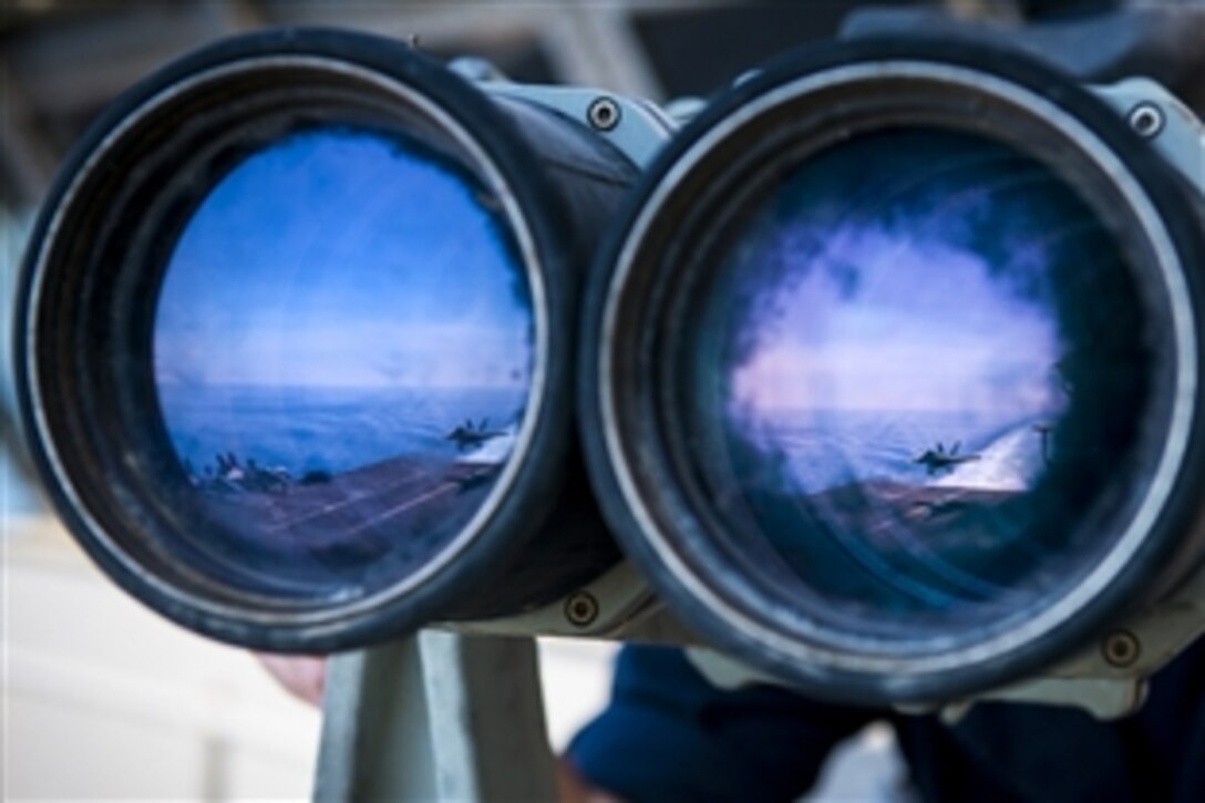 U.S. Navy Petty Officer 3rd Class Jonathan Wenrich uses high-powered binoculars to scan the horizon from the aircraft carrier USS Carl Vinson in the Persian Gulf, Feb. 28, 2015. The Carl Vinson is conducting flight operations as part of Operation Inherent Resolve. 