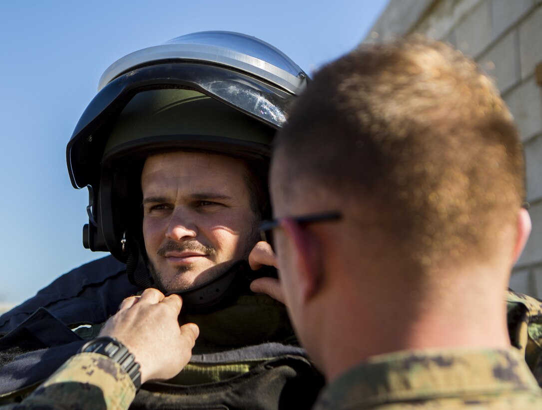 A U.S. Marine explosive ordnance disposal technician, right, with Special-Purpose Marine Air-Ground Task Force Crisis Response-Africa secures a bomb suit to Cabo Primero Antonio Diosdade, , a noncommissioned officer with Unidad Militar de Emergencias, an emergency response unit, during a joint training event at Morón Air Base, Spain, Feb. 18, 2015. The Marines demonstrated the different capabilities of their equipment for Spanish forces, who then provided a guided tour of the UME disaster training site to set the stage for future training opportunities. (U.S. Marine Corps photograph by Lance Cpl. Christopher Mendoza/Released)
