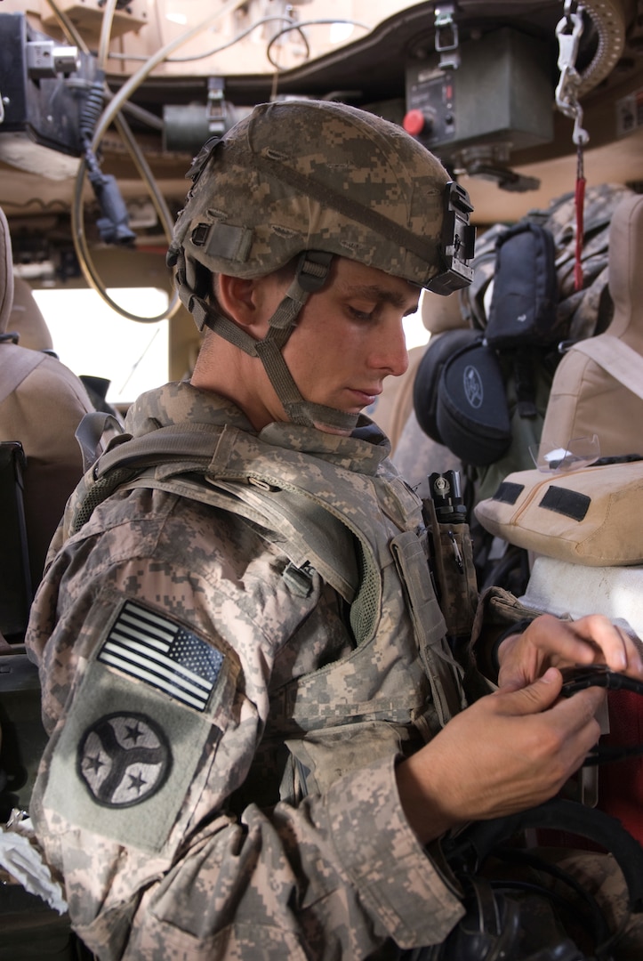 Spc. Brandon Watkins, a .50 caliber Browning machine-gunner for 2nd Platoon, Troop K, 3rd Squadron, 278th Armored Cavalry Regiment of the Tennessee National Guard, prepares to put on his head-set prior to providing security for a convoy transporting equipment and assets from Contingency Operating Base Q-West, Iraq, June 10, 2010.