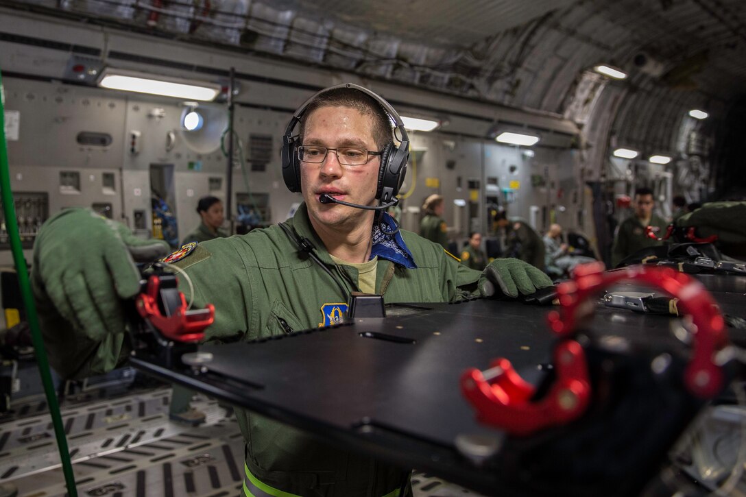 Tech. Sgt. James Laska finishes configuring a newly approved C-17 stanchion litter system Feb. 22, 2015 during a training mission in San Juan, Puerto Rico. The mission was part of a three day fly-away with Airmen from the 315th Airlift Wing at Joint Base Charleston, South Carolina and aeromedical Airmen from the 459th Air Refueling Wing at Joint Base Andrews, Maryland. The training mission was a cost-effective means to accomplish currency items and evaluations for flight crew members and provided C-17 familiarization and proficiency training for aeromedical Airmen. Laska is an aeromedical technician with the 459th Aeromedical Evacuation Squadron. (U.S. Air Force Photo/Tech. Sgt. Shane Ellis)
