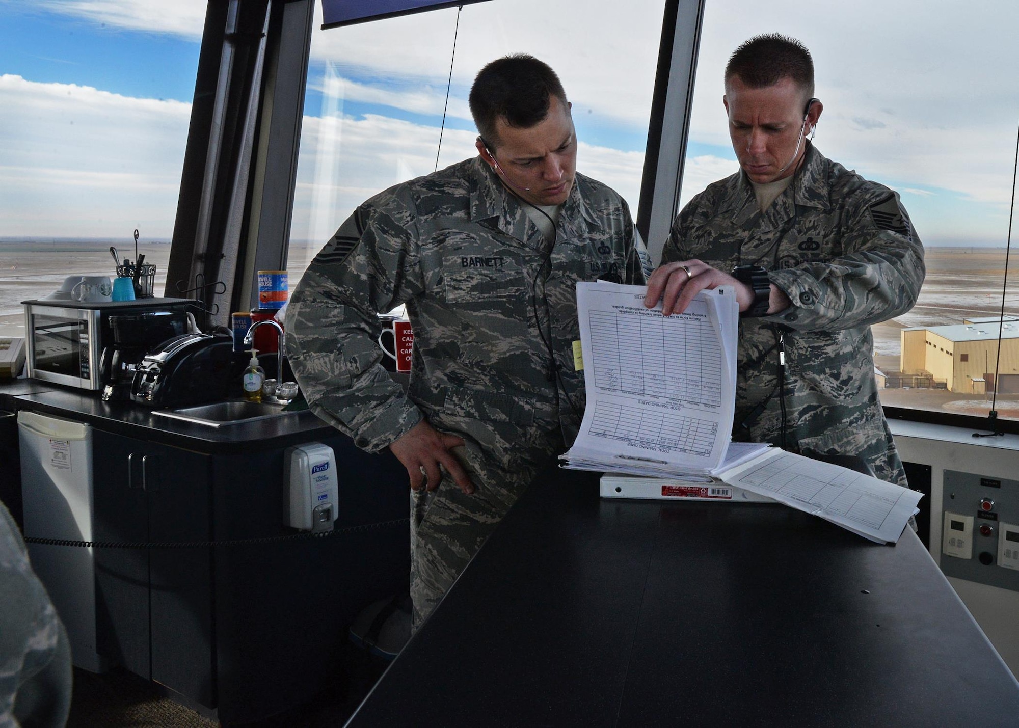 U.S. Air Force Master Sgt. Jade Barnett, 27th Special Operations Support Squadron assistant chief controller and Master Sgt. Clint Dykes, 27th SOSS chief controller, review training documents in the tower Feb. 24, 2015 at Cannon Air Force Base, N.M. Both Barnett and Dykes are responsible for the training of the 34 controllers assigned to Cannon. (U.S. Air Force photo/Airman 1st Class Chip Slack)