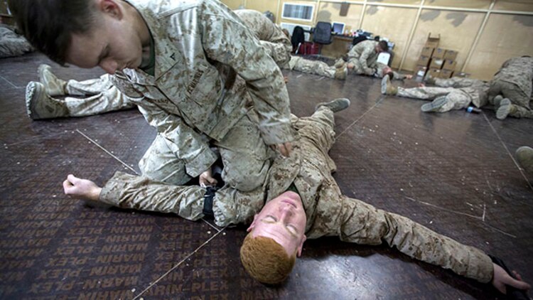 Lance Cpl. Tyler Montana, top, a rifleman with India Company, Battalion Landing Team 3rd Battalion, 6th Marine Regiment, 24th Marine Expeditionary Unit, applies a simulated tourniquet to  a role player during  combat life-saver training  at Camp Buehring, Kuwait, Feb. 2, 2015. A contingent of 24th MEU Marines is conducting scheduled sustainment training in Kuwait. The 24th MEU is embarked on the ships of the Iwo Jima Amphibious Ready Group and deployed to maintain regional security in the U.S. 5th Fleet area of operations.