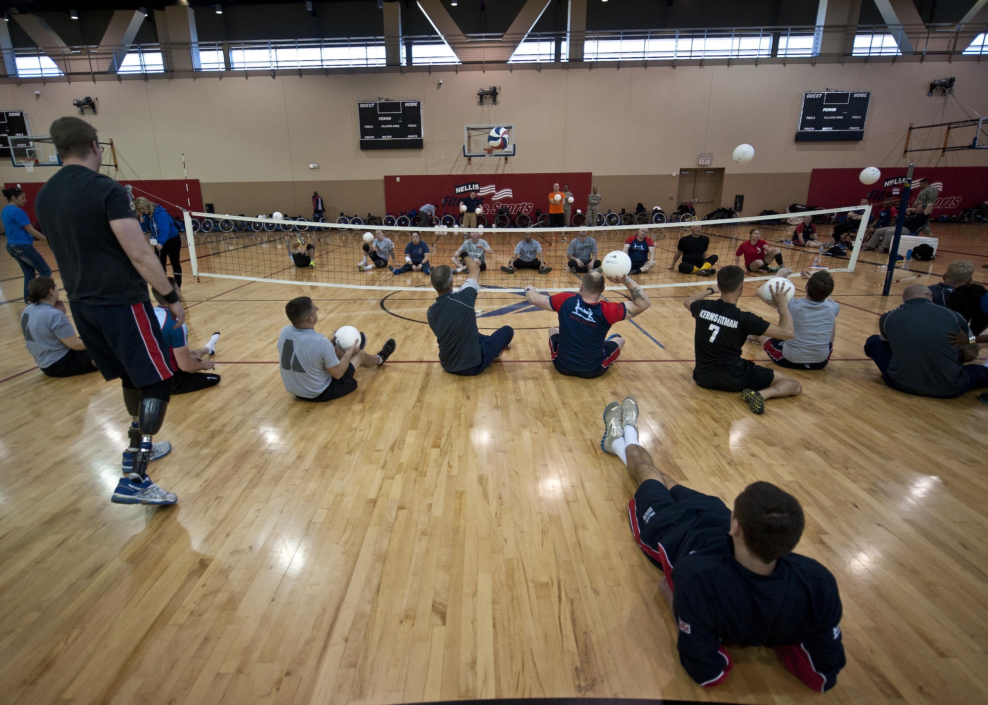 Members of the U.S. Army’s wounded warrior sitting volleyball team practices with members of the British wounded warrior team Feb. 27, 2015, during the 2015 U.S. Air Force Trials at Nellis Air Force Base, Nev. Participants in the trials will compete in wheelchair basketball, wheelchair rugby, sitting volleyball, swimming, track and field, air pistol and rifle shooting, archery and cycling. (U.S. Air Force photo/Staff Sgt. Siuta B. Ika)