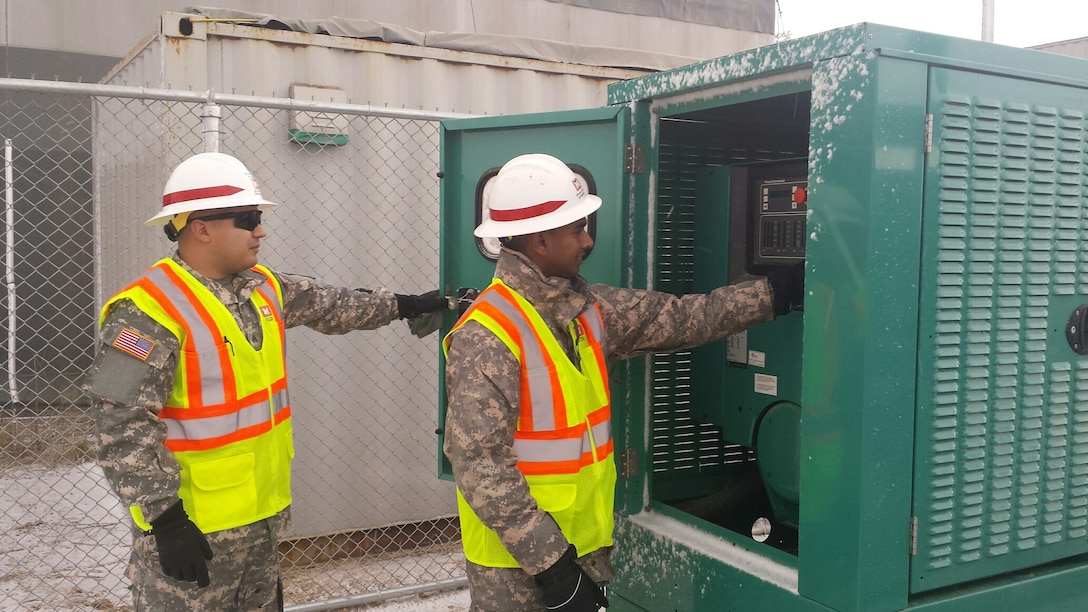 Sgt. Alfredo Alvarez (left) and Sgt. Dinesh Liyanage, members of the 249th Engineer Battalion - Prime Power, inspect a generator panel at a troop housing area construction site on U.S. Army Garrison Humphreys in February 2015. The Soldiers are on a 100 day temporary duty at the district providing expertise in electrical engineering. 