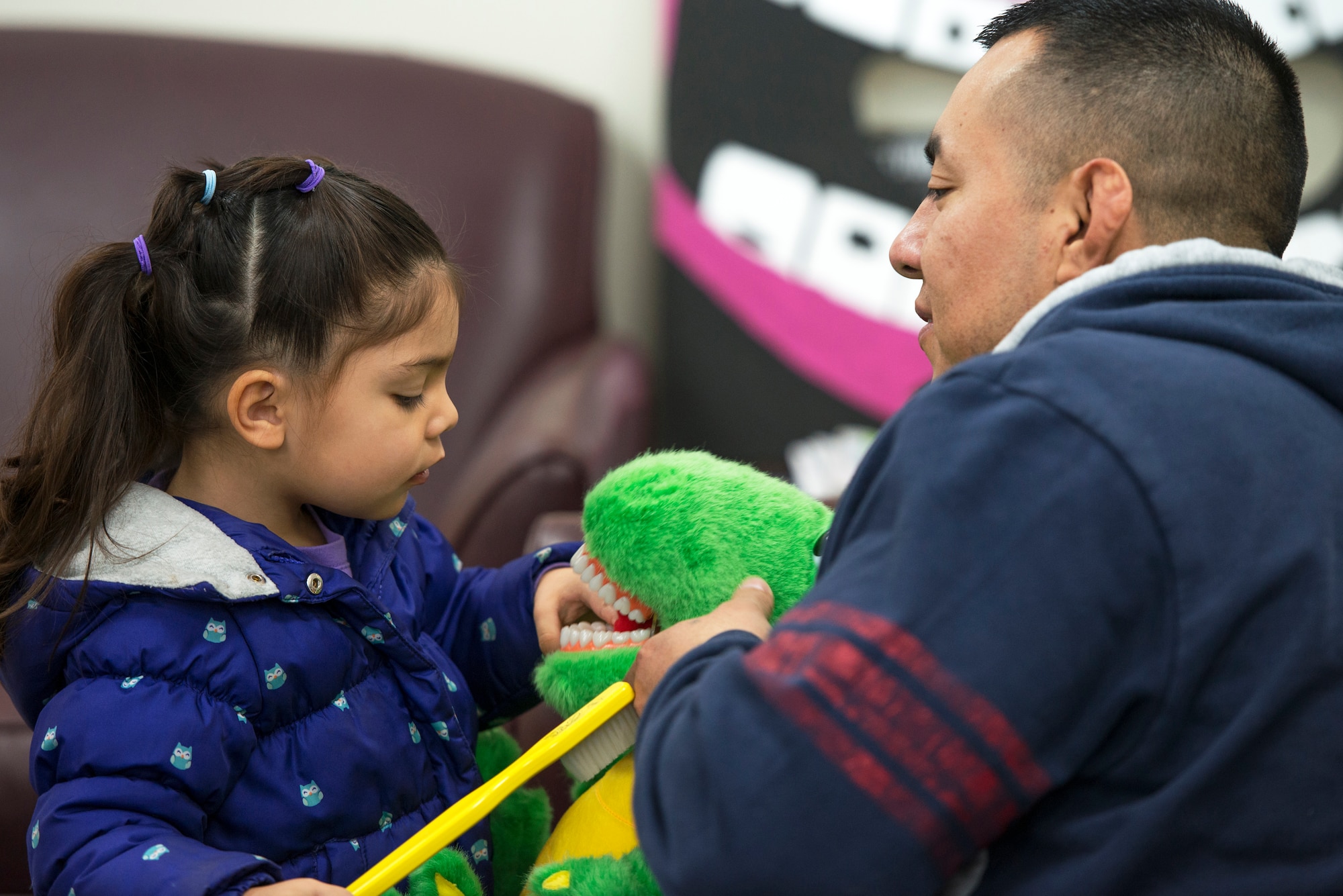 A father and daughter play with a stuffed animal at the Yokota Dental Clinic, Feb. 28, 2015, during the Little Teeth-Big Smiles event. As part of National Children's Dental Health Month, the 374th Dental Squadron hosted a walk-in clinic, offering preventative services for children up to 10 years old, including dental examinations, cleanings and education services. (U.S. Air Force photo by Airman 1st Class Delano Scott/Released) 