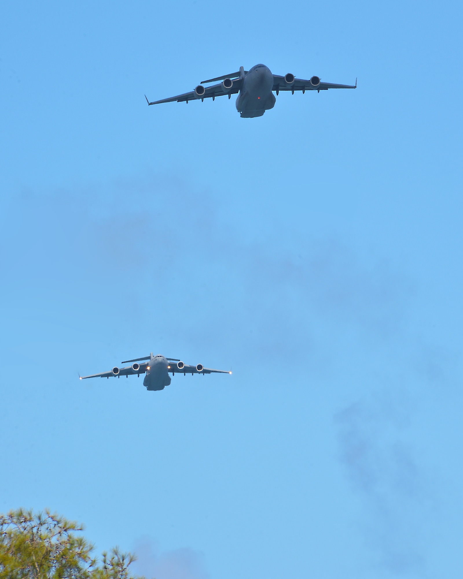Two C-17 Globalmaster III aircraft, from the 535th Air Lift Squadron at Joint Base Pearl Harbor-Hickam, Hawaii, approach the drop zone on Kahuku Training Area, Hawaii, March 2, 2015. Each aircraft has four combat delivery systems containing meals-ready-to-eat and ammunition containers in support of the25th Infantry Division’s exercise Lightning Forge. (U.S. Air Force photo by Tech. Sgt. Aaron Oelrich/Released)